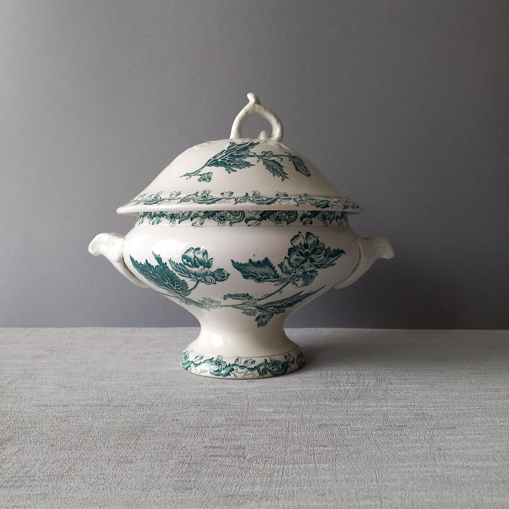 A delightful small-sized antique ironstone soup tureen by French manufacturer, St. Amand. This tureen is adorned with a beautiful teal coloured floral transferware pattern and has a splendid little handle on the lid. In summary, an elegant piece with just enough patina of age to give it character.