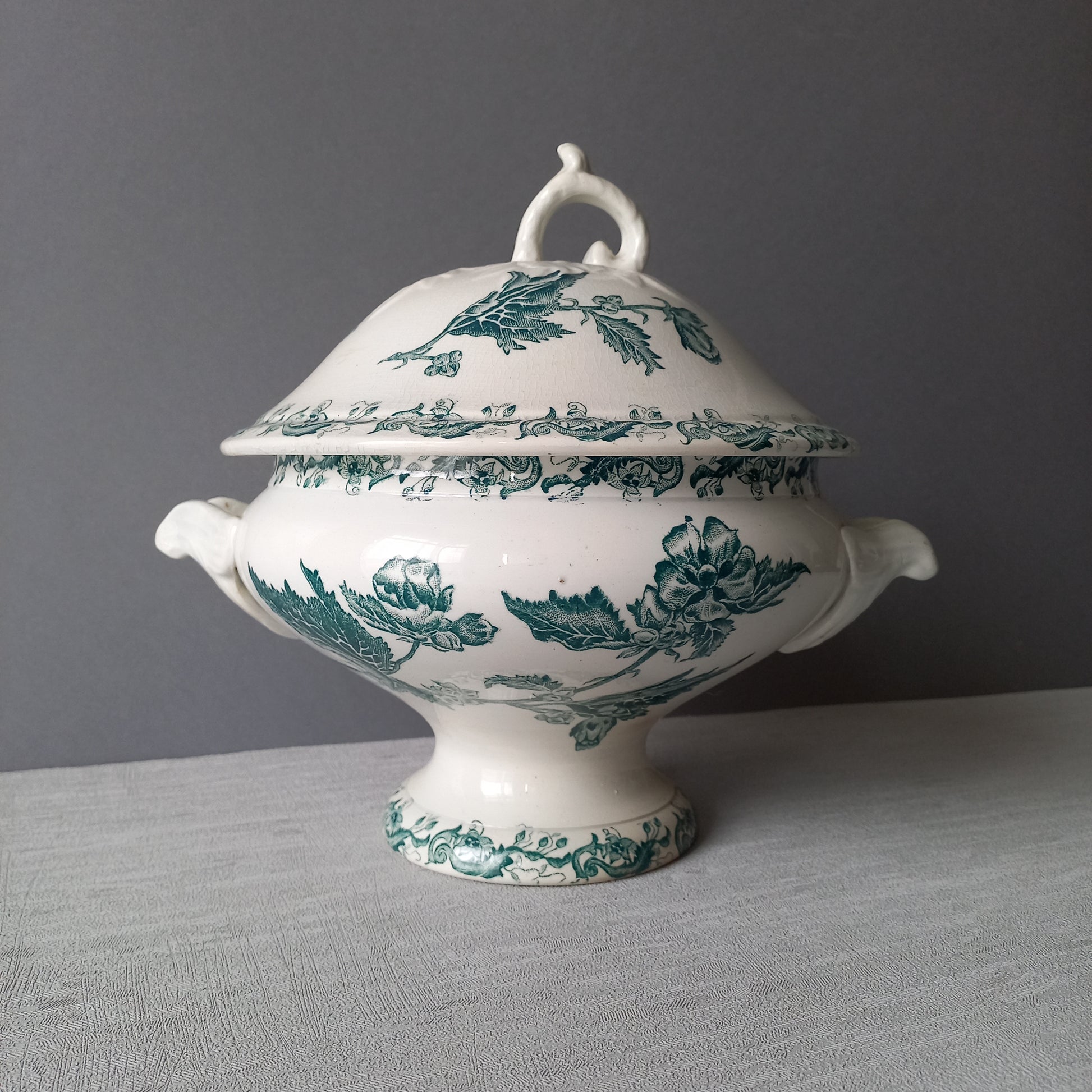 A delightful small-sized antique ironstone soup tureen by French manufacturer, St. Amand. This tureen is adorned with a beautiful teal coloured floral transferware pattern and has a splendid little handle on the lid. In summary, an elegant piece with just enough patina of age to give it character.