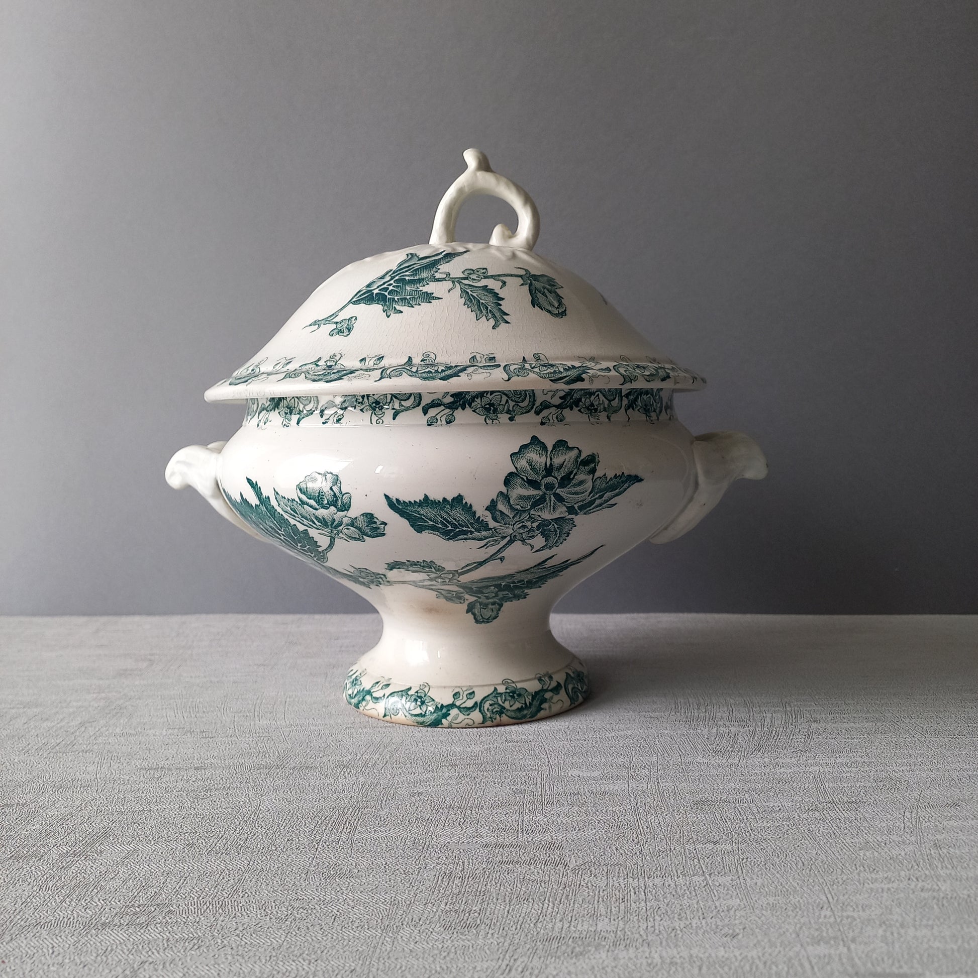 A delightful small-sized antique ironstone soup tureen by French manufacturer, St. Amand. This tureen is adorned with a beautiful teal coloured floral transferware pattern and has a splendid little handle on the lid. In summary, an elegant piece with just enough patina of age to give it character.