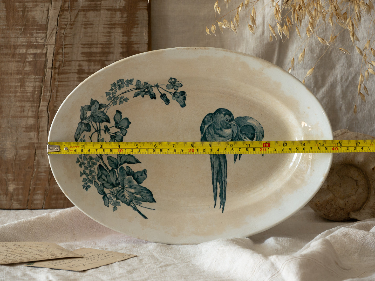 An absolutely stunning large French antique oval ironstone serving plate in a delightful time-worn creamy white with blue transferware pattern depicting two cute birds and flowers.