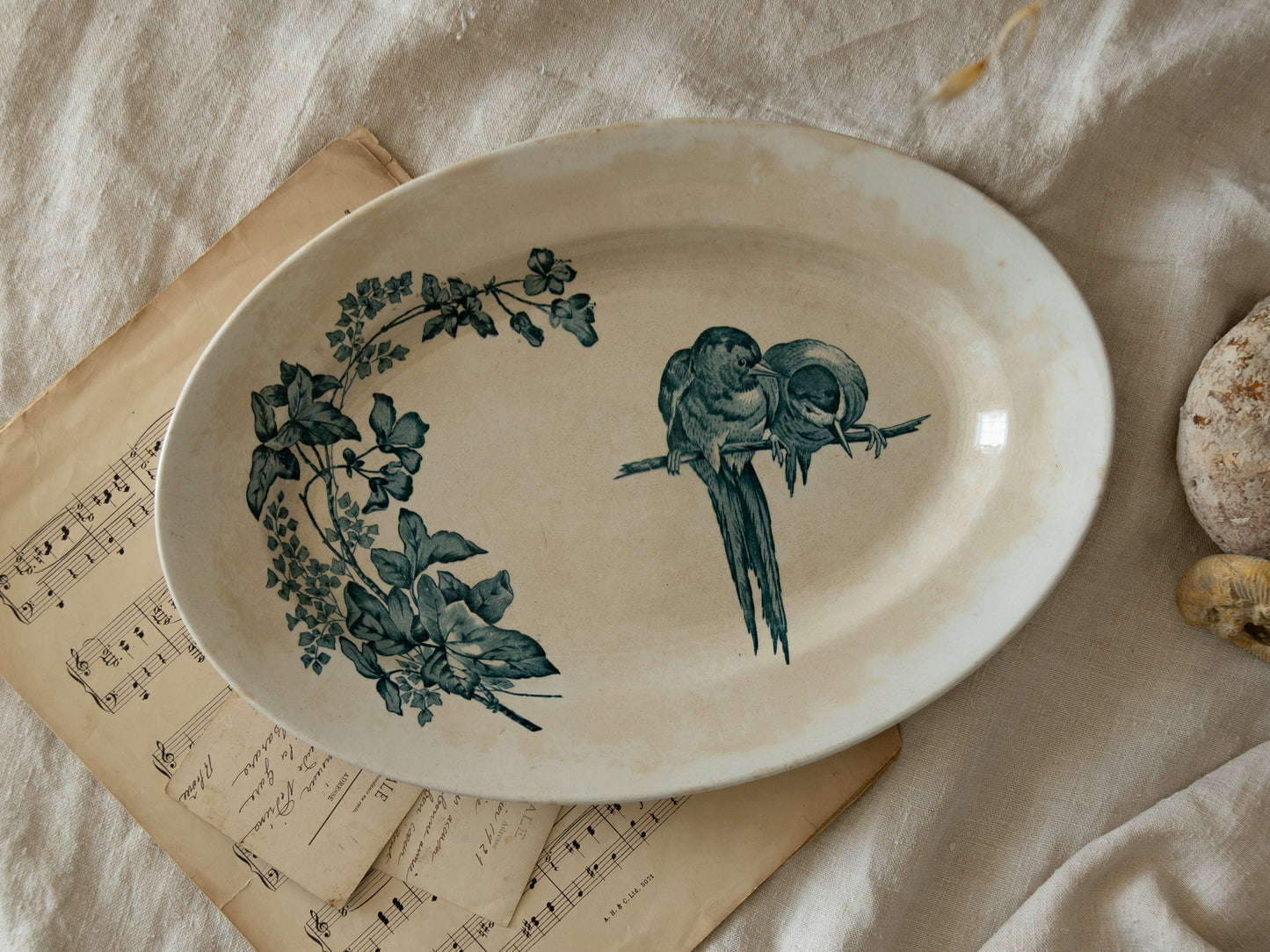 An absolutely stunning large French antique oval ironstone serving plate in a delightful time-worn creamy white with blue transferware pattern depicting two cute birds and flowers.