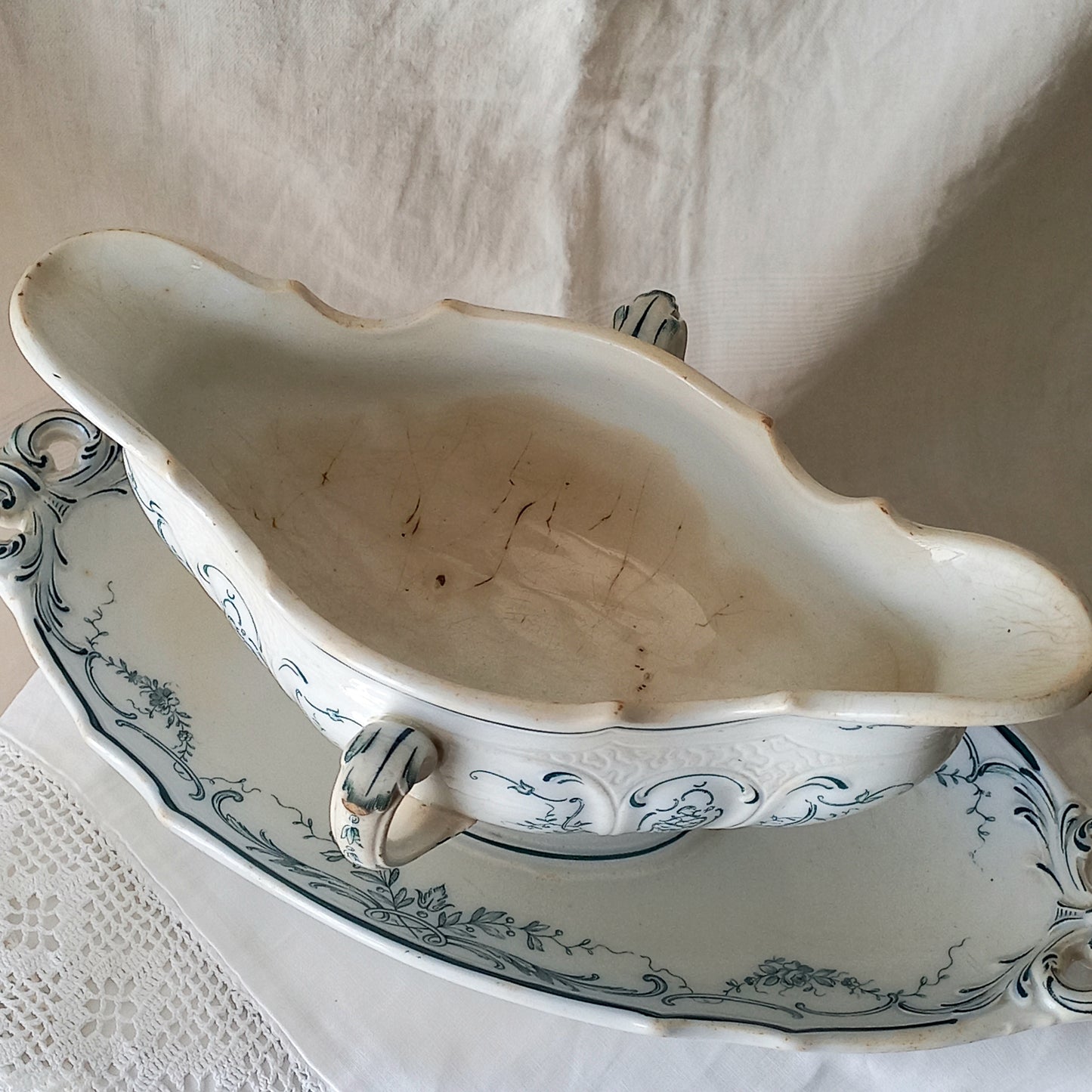 A large and elegant antique ironstone sauce boat with a green floral transferware pattern, a grand-looking, heavy piece. These days this piece will make an excellent piece of decor in any home, especially those of a country or farmhouse nature.