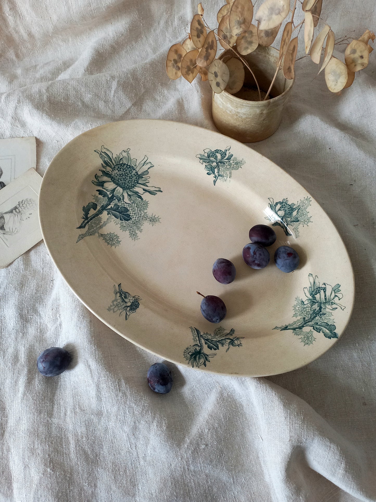 French antique oval ironstone serving plate with teal colour sunflower transferware pattern that over many decades has become a pleasing, warm shade of creamy white with crazing and tea-staining.