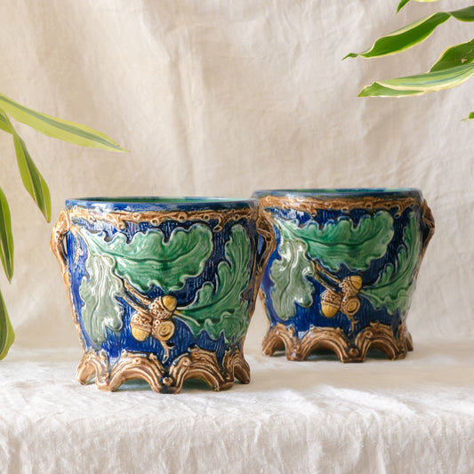 A stunning pair of French antique majolica planters, absolutely glorious fresh blue and green colours with oak leafs and acorns in relief making these stunning pieces of interior home decor wherever you decide to display them.
One of the planters has an antique repair in the form of metal staples that have been expertly done from the inside - in the 1800s and early 1900s this was quite a common repair to have made on items of high value and we feel it only adds to the authenticity/story of these pieces.