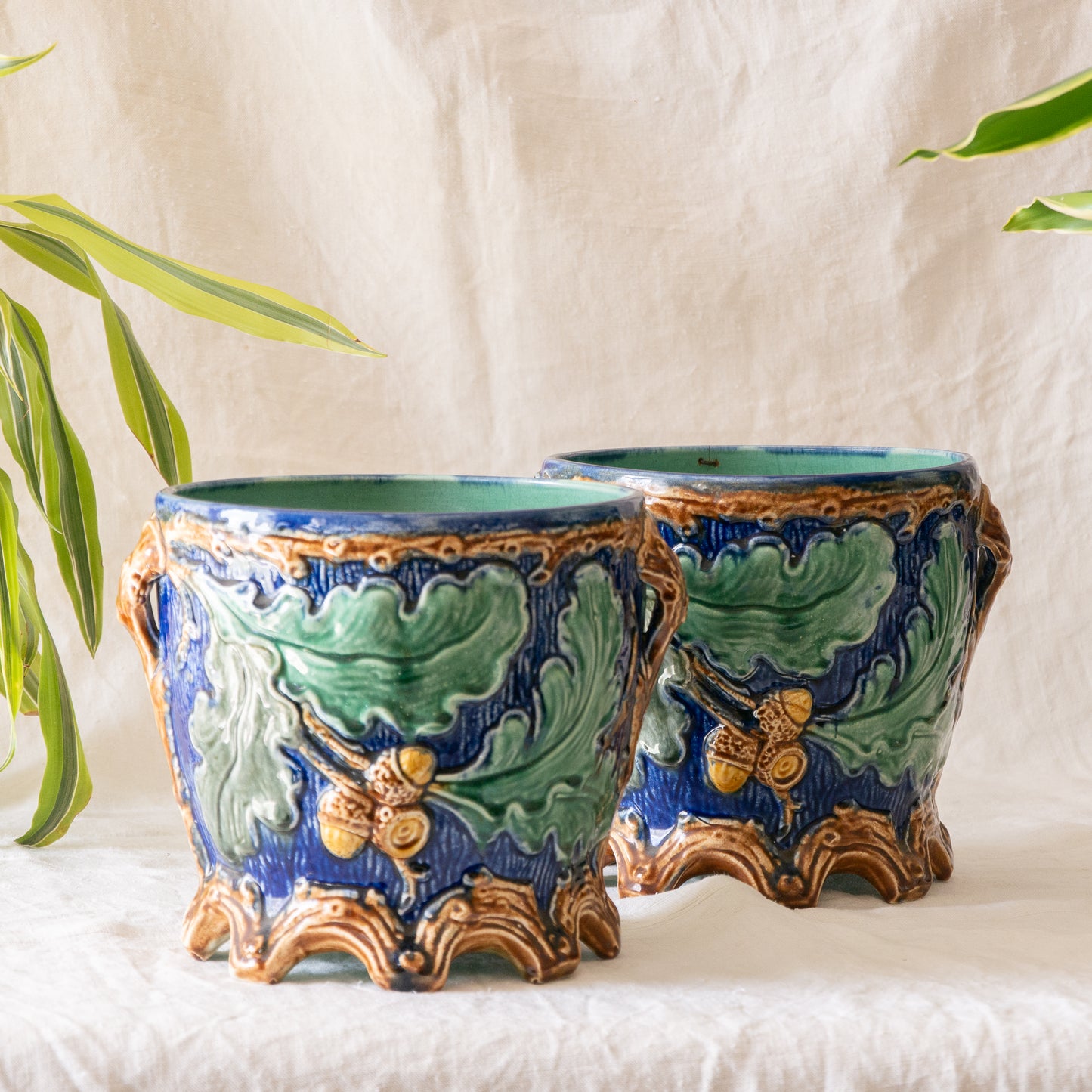 A stunning pair of French antique majolica planters, absolutely glorious fresh blue and green colours with oak leafs and acorns in relief making these stunning pieces of interior home decor wherever you decide to display them.
One of the planters has an antique repair in the form of metal staples that have been expertly done from the inside - in the 1800s and early 1900s this was quite a common repair to have made on items of high value and we feel it only adds to the authenticity/story of these pieces.
