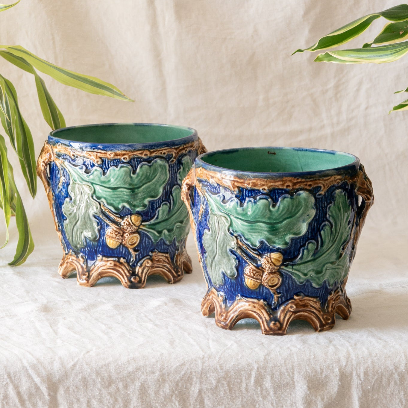 A stunning pair of French antique majolica planters, absolutely glorious fresh blue and green colours with oak leafs and acorns in relief making these stunning pieces of interior home decor wherever you decide to display them.
One of the planters has an antique repair in the form of metal staples that have been expertly done from the inside - in the 1800s and early 1900s this was quite a common repair to have made on items of high value and we feel it only adds to the authenticity/story of these pieces.
