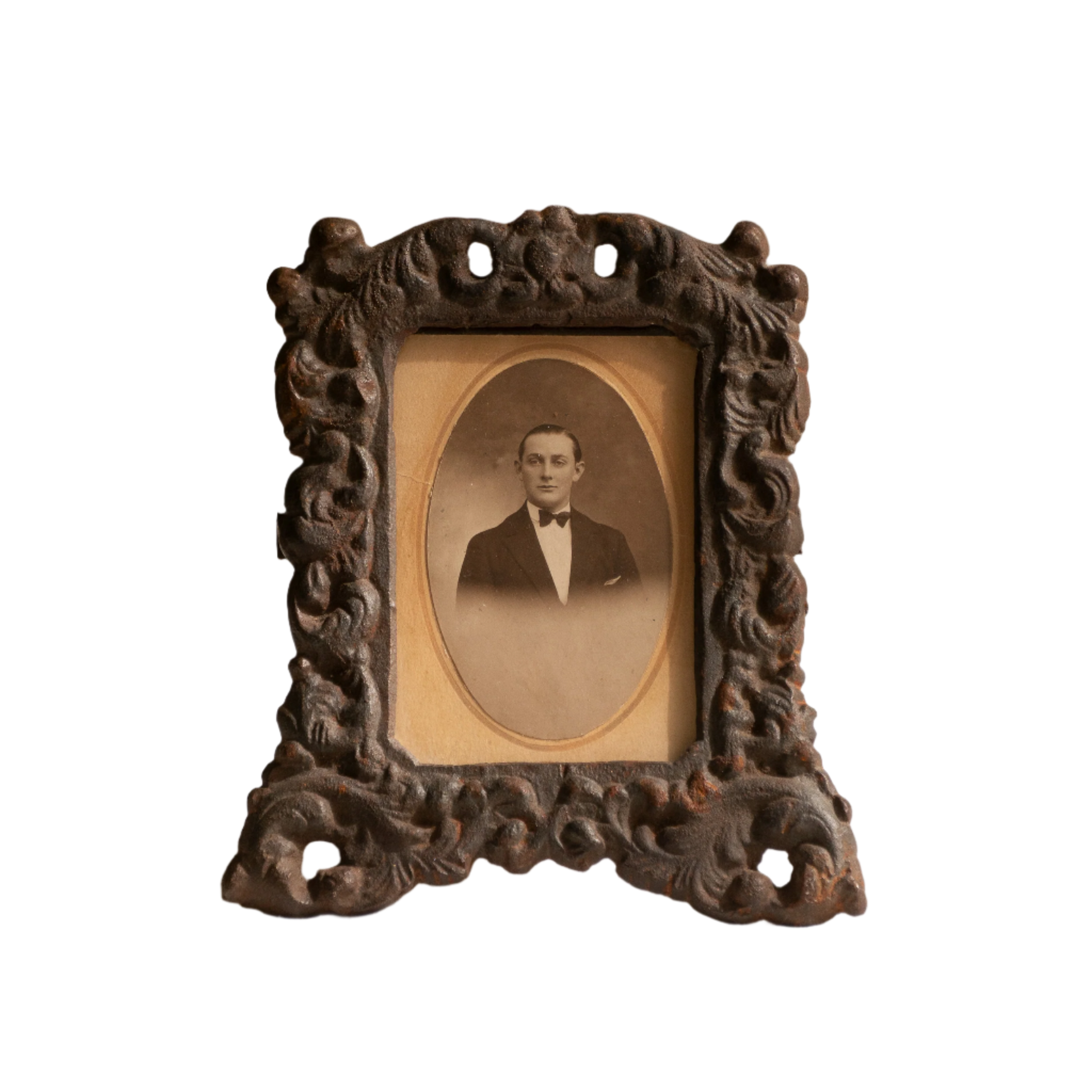 A small French antique decorative cast iron photo frame - a very interesting artisan-made table-top frame with wonderful time-worn patina. There is a glass front and a hardboard backing board. The photo of the gentleman in a tuxedo is an original French period photo that we have placed inside for display purposes and is included in the sale.