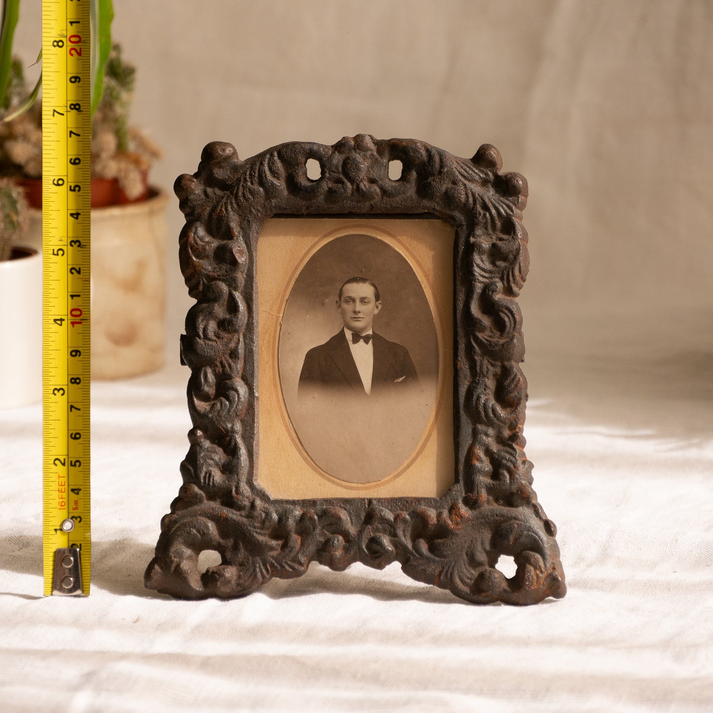 A small French antique decorative cast iron photo frame - a very interesting artisan-made table-top frame with wonderful time-worn patina. There is a glass front and a hardboard backing board. The photo of the gentleman in a tuxedo is an original French period photo that we have placed inside for display purposes and is included in the sale.