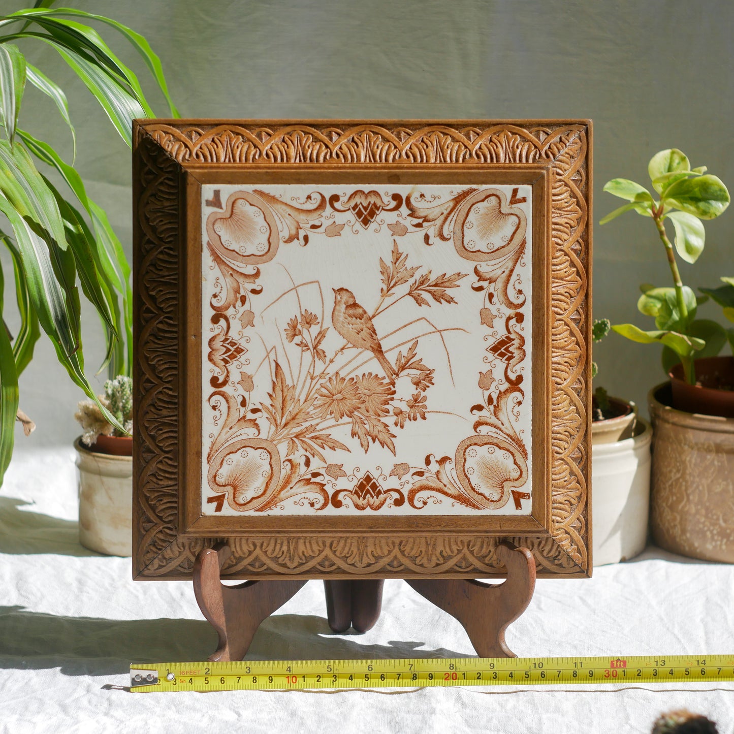 A beautiful French antique wooden trivet with a ceramic bird and floral tile insert. The wooden frame is very decorative with patterns around all four edges while the ceramic tile has aged just enough, the tasteful off-white and light brown colour scheme making this piece a most welcome addition to any kitchen as decor or perhaps as a decorative plant pot stand.