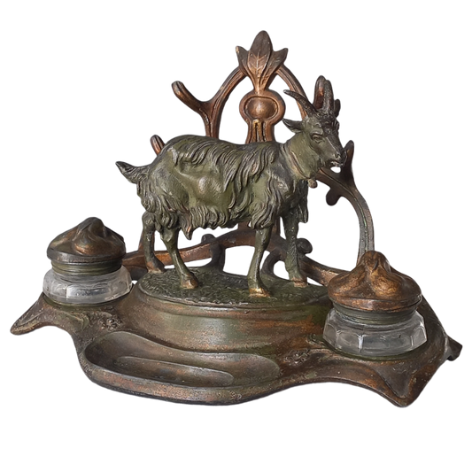 A stunning French art nouveau double inkwell with a goat figurine.
This wonderful antique inkwell has been sculpted in metal and signed by the artist (see photos). Behind the beautiful goat figurine are two pen rests and either side of the goat are two small glass ink pots with decorative metal lids.
The metal is finished in a lovely shade of green that has worn over time with traces of gold colour beneath - it has a wonderful patina of time all over it.