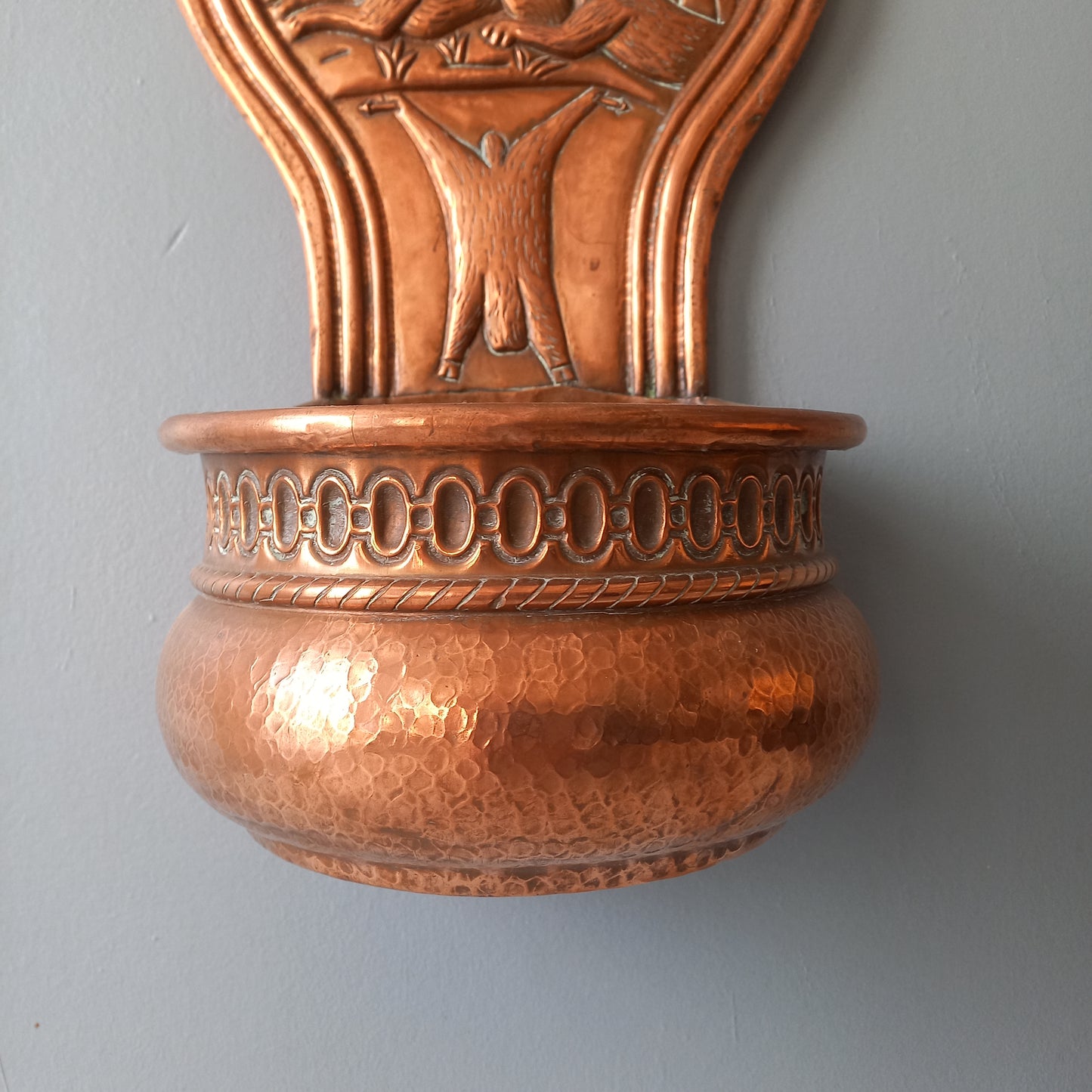 A very handsome copper vintage/antique wall-mounted planter with a hunting scene that I purchased in south west France.
This wonderful rustic piece may at some time have had another purpose, although being a planter seems to suit it just perfectly. There is a hanging hook to the rear, although it can also be displayed sitting on a flat surface as it's depicted in my photos - it's very interesting that we can also see the crude yet charming way this heavy copper planter was constructed by the artisan.