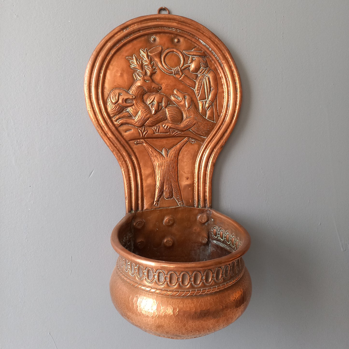 A very handsome copper vintage/antique wall-mounted planter with a hunting scene that I purchased in south west France.
This wonderful rustic piece may at some time have had another purpose, although being a planter seems to suit it just perfectly. There is a hanging hook to the rear, although it can also be displayed sitting on a flat surface as it's depicted in my photos - it's very interesting that we can also see the crude yet charming way this heavy copper planter was constructed by the artisan.