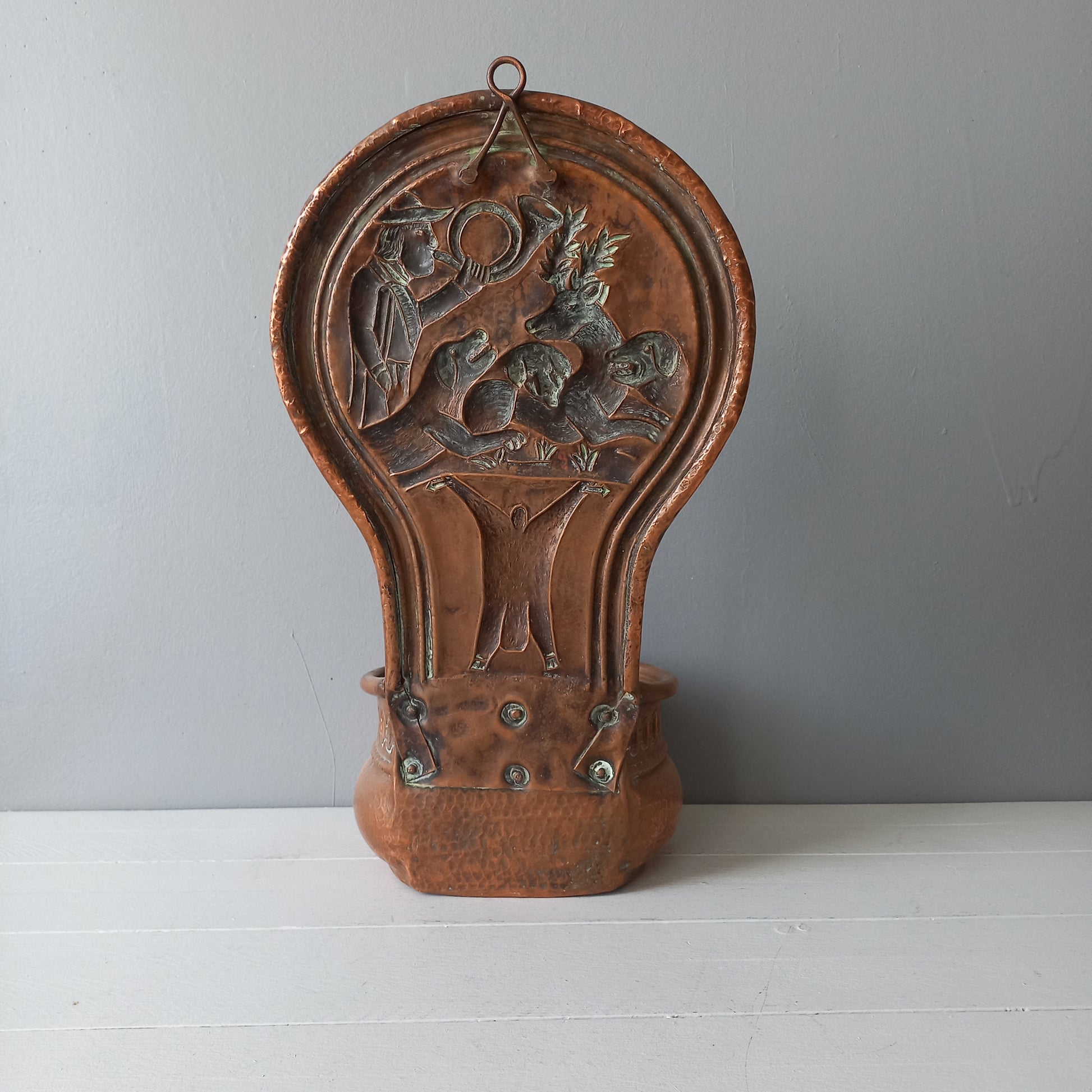 A very handsome copper vintage/antique wall-mounted planter with a hunting scene that I purchased in south west France.
This wonderful rustic piece may at some time have had another purpose, although being a planter seems to suit it just perfectly. There is a hanging hook to the rear, although it can also be displayed sitting on a flat surface as it's depicted in my photos - it's very interesting that we can also see the crude yet charming way this heavy copper planter was constructed by the artisan.