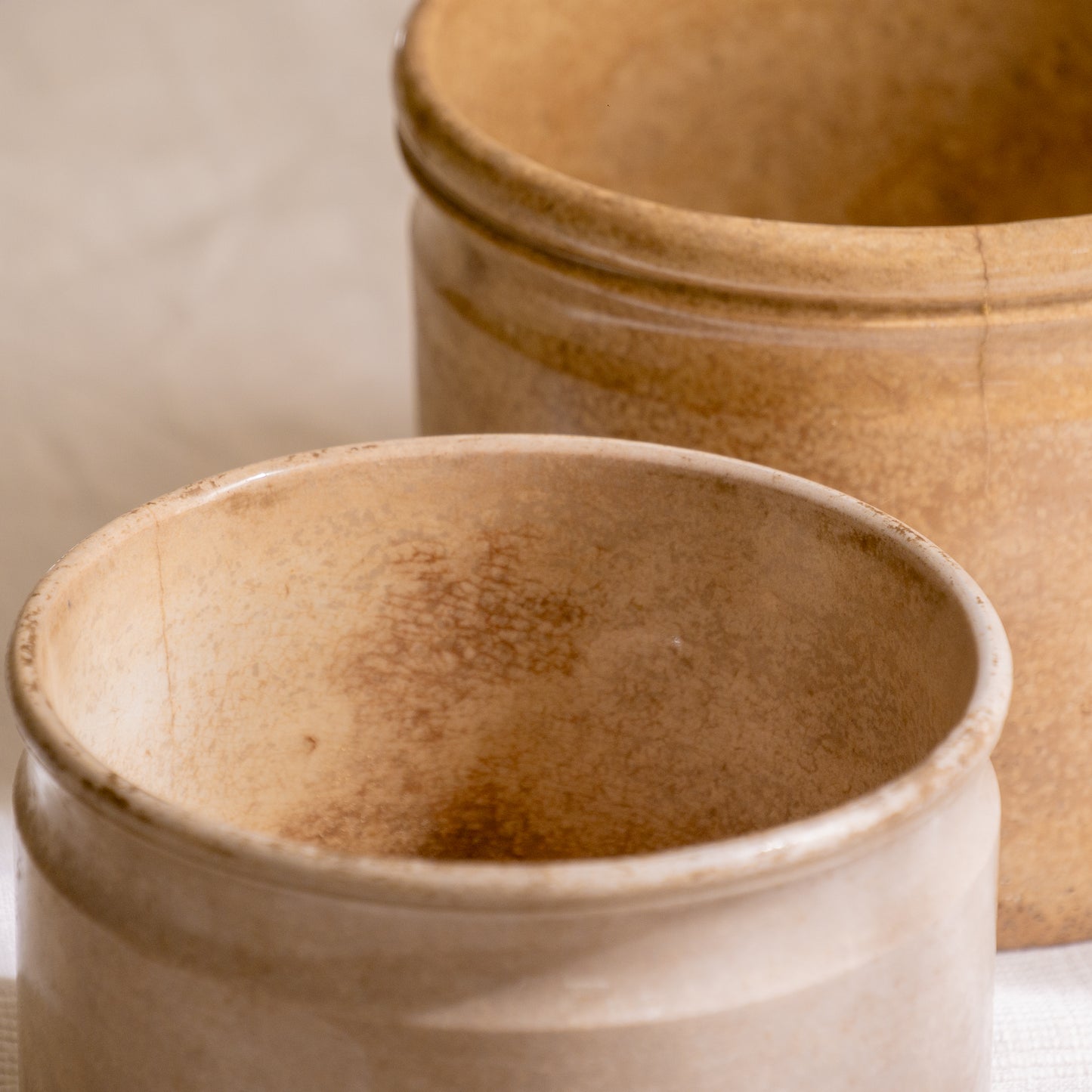 A pair of French antique tea-stained white to creamy brown ironstone crock pots or preserve pots.
In the past these small pots were quintessential pieces in French kitchens for storing jam, etc, and these days are still just as useful for items such as utensils.
Smaller pot was manufactured by Choisy le Roi, circa. late 1800s. The larger pot has no maker's mark - circa. late 1800s/early 1900s.