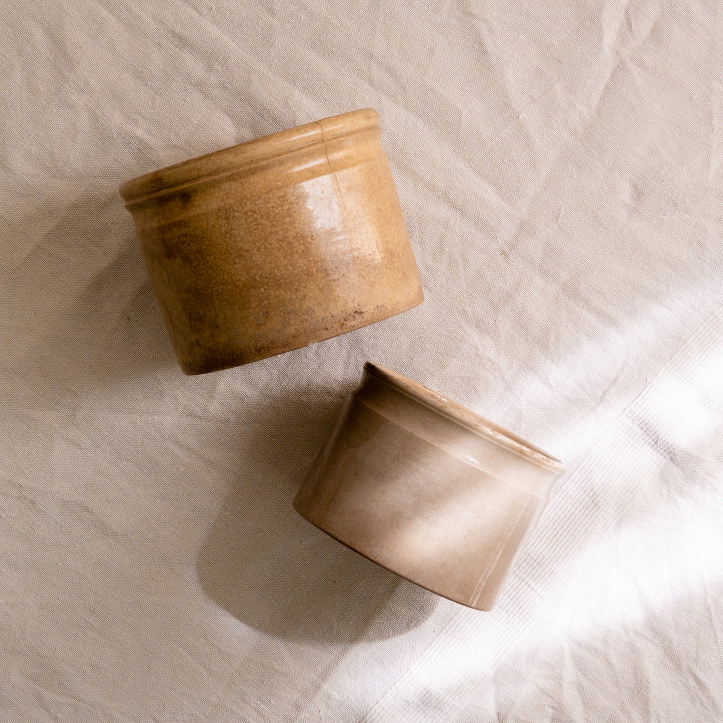 A pair of French antique tea-stained white to creamy brown ironstone crock pots or preserve pots.
In the past these small pots were quintessential pieces in French kitchens for storing jam, etc, and these days are still just as useful for items such as utensils.
Smaller pot was manufactured by Choisy le Roi, circa. late 1800s. The larger pot has no maker's mark - circa. late 1800s/early 1900s.
