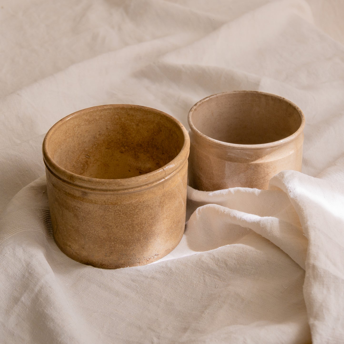 A pair of French antique tea-stained white to creamy brown ironstone crock pots or preserve pots.
In the past these small pots were quintessential pieces in French kitchens for storing jam, etc, and these days are still just as useful for items such as utensils.
Smaller pot was manufactured by Choisy le Roi, circa. late 1800s. The larger pot has no maker's mark - circa. late 1800s/early 1900s.