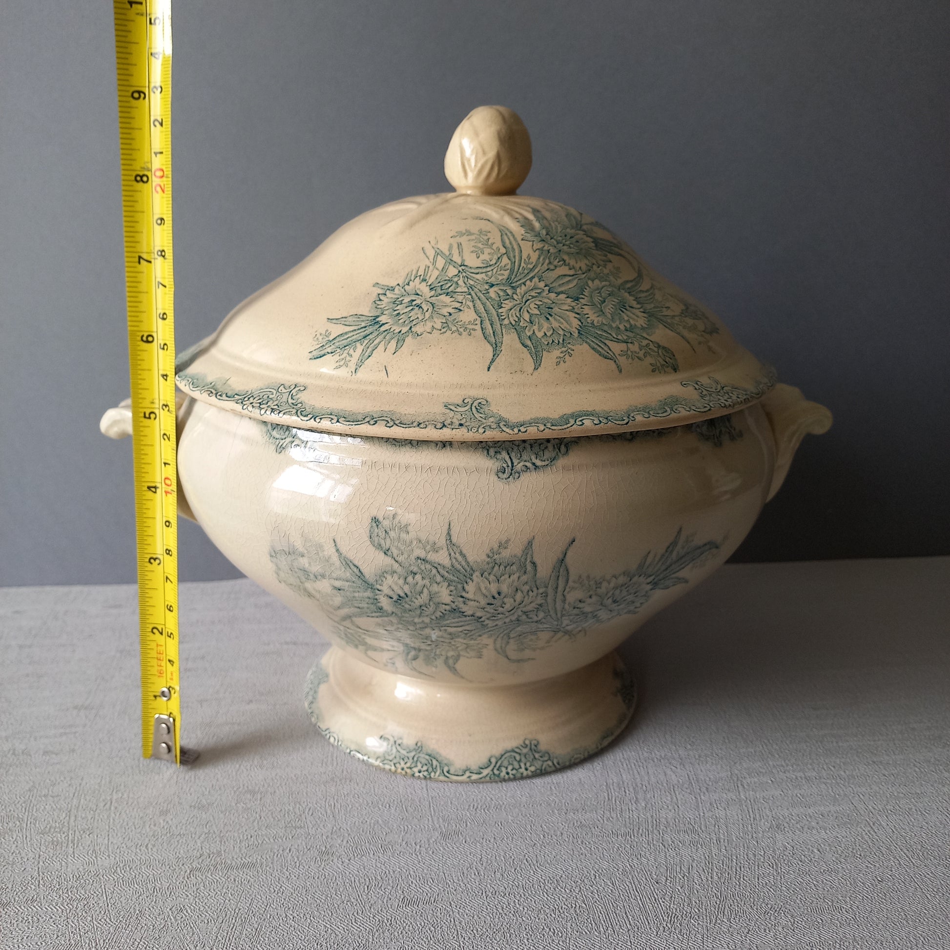 A pretty antique ironstone soup tureen with aged and faded floral transfer pattern in a beautiful shade of blue green or teal. Over time this wonderful old tureen has developed a pleasing faded creamy white finish. In summary, a beautiful piece of authentic antique ironstone from France.