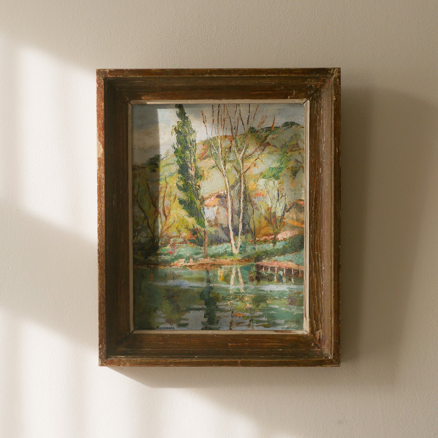 An original vintage landscape oil painting depicting a charming country home in among a wooded area with hills in the background. In the foreground a gentle river reflects the trees in the background.
The painting has been painted by an experienced artist with confident brush strokes - a really wonderful piece of original art.
The painting is presented in an old worn wooden frame which we love and think others will too - it really suits this piece.