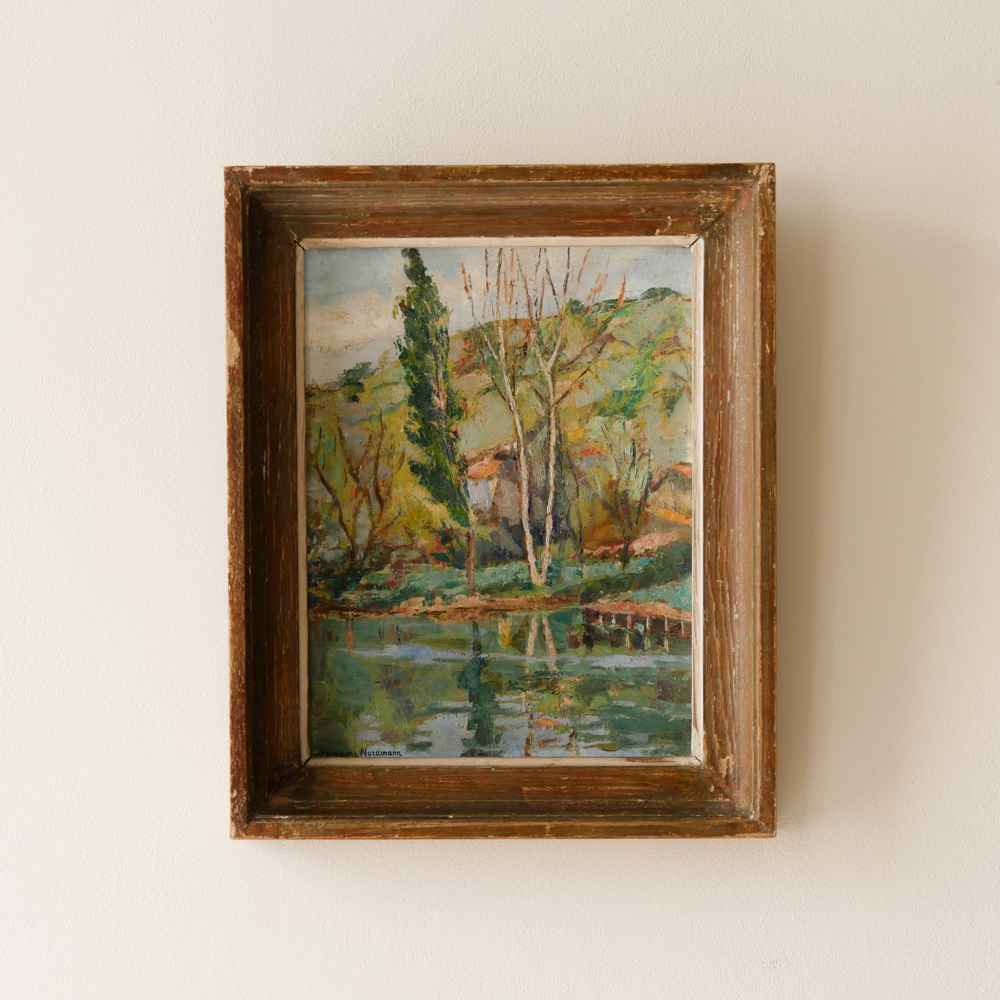 An original vintage landscape oil painting depicting a charming country home in among a wooded area with hills in the background. In the foreground a gentle river reflects the trees in the background.
The painting has been painted by an experienced artist with confident brush strokes - a really wonderful piece of original art.
The painting is presented in an old worn wooden frame which we love and think others will too - it really suits this piece.