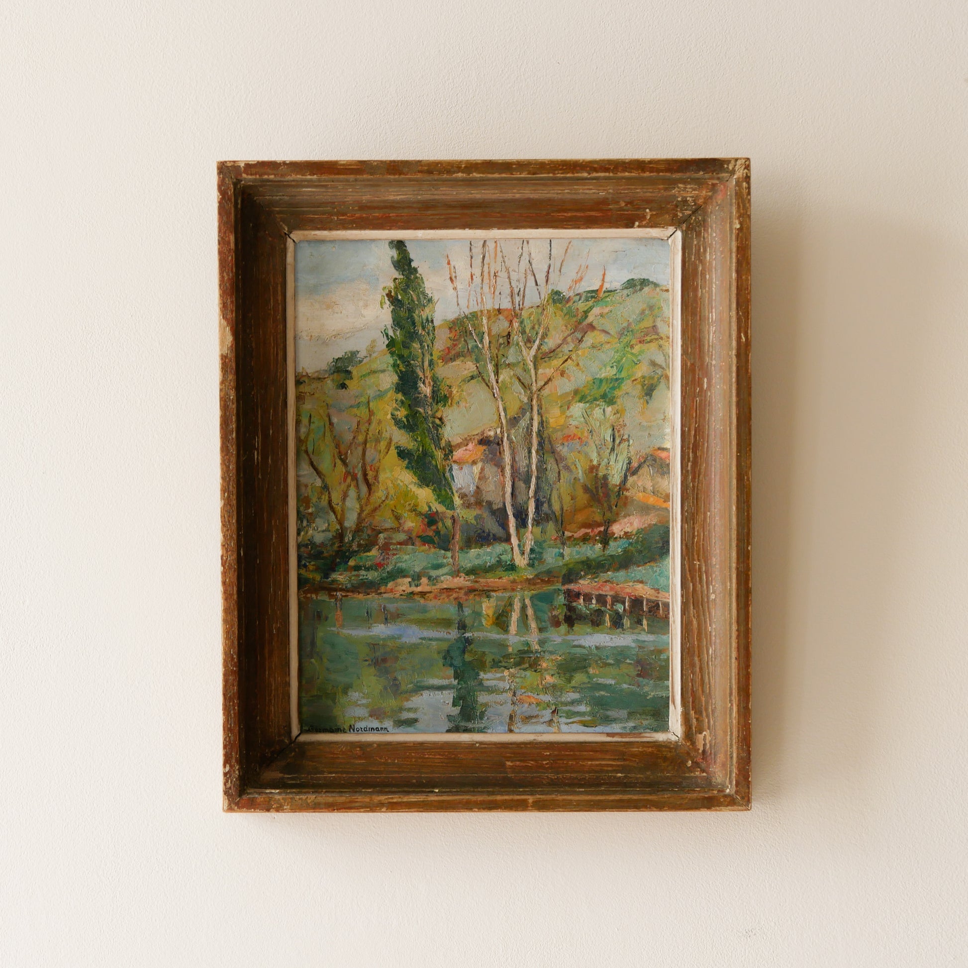 An original vintage landscape oil painting depicting a charming country home in among a wooded area with hills in the background. In the foreground a gentle river reflects the trees in the background.
The painting has been painted by an experienced artist with confident brush strokes - a really wonderful piece of original art.
The painting is presented in an old worn wooden frame which we love and think others will too - it really suits this piece.
