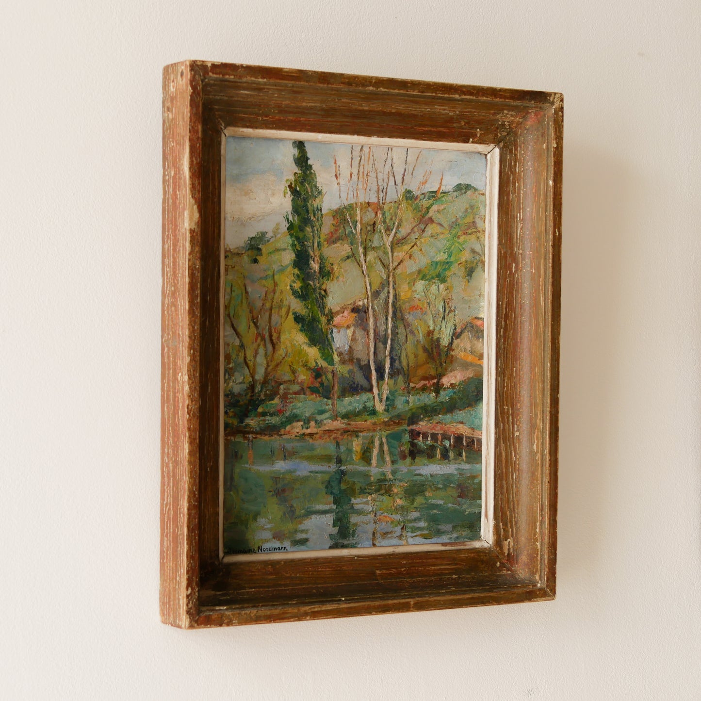 An original vintage landscape oil painting depicting a charming country home in among a wooded area with hills in the background. In the foreground a gentle river reflects the trees in the background.
The painting has been painted by an experienced artist with confident brush strokes - a really wonderful piece of original art.
The painting is presented in an old worn wooden frame which we love and think others will too - it really suits this piece.