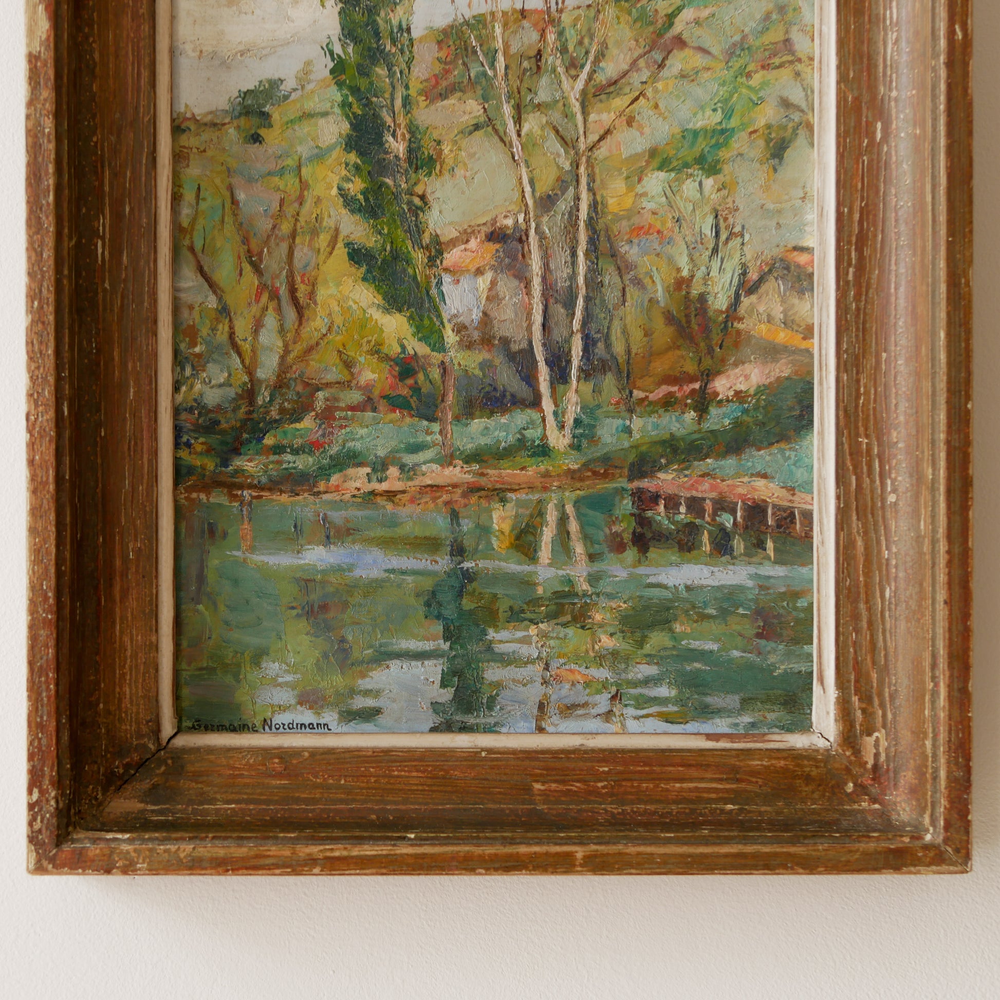 An original vintage landscape oil painting depicting a charming country home in among a wooded area with hills in the background. In the foreground a gentle river reflects the trees in the background.
The painting has been painted by an experienced artist with confident brush strokes - a really wonderful piece of original art.
The painting is presented in an old worn wooden frame which we love and think others will too - it really suits this piece.