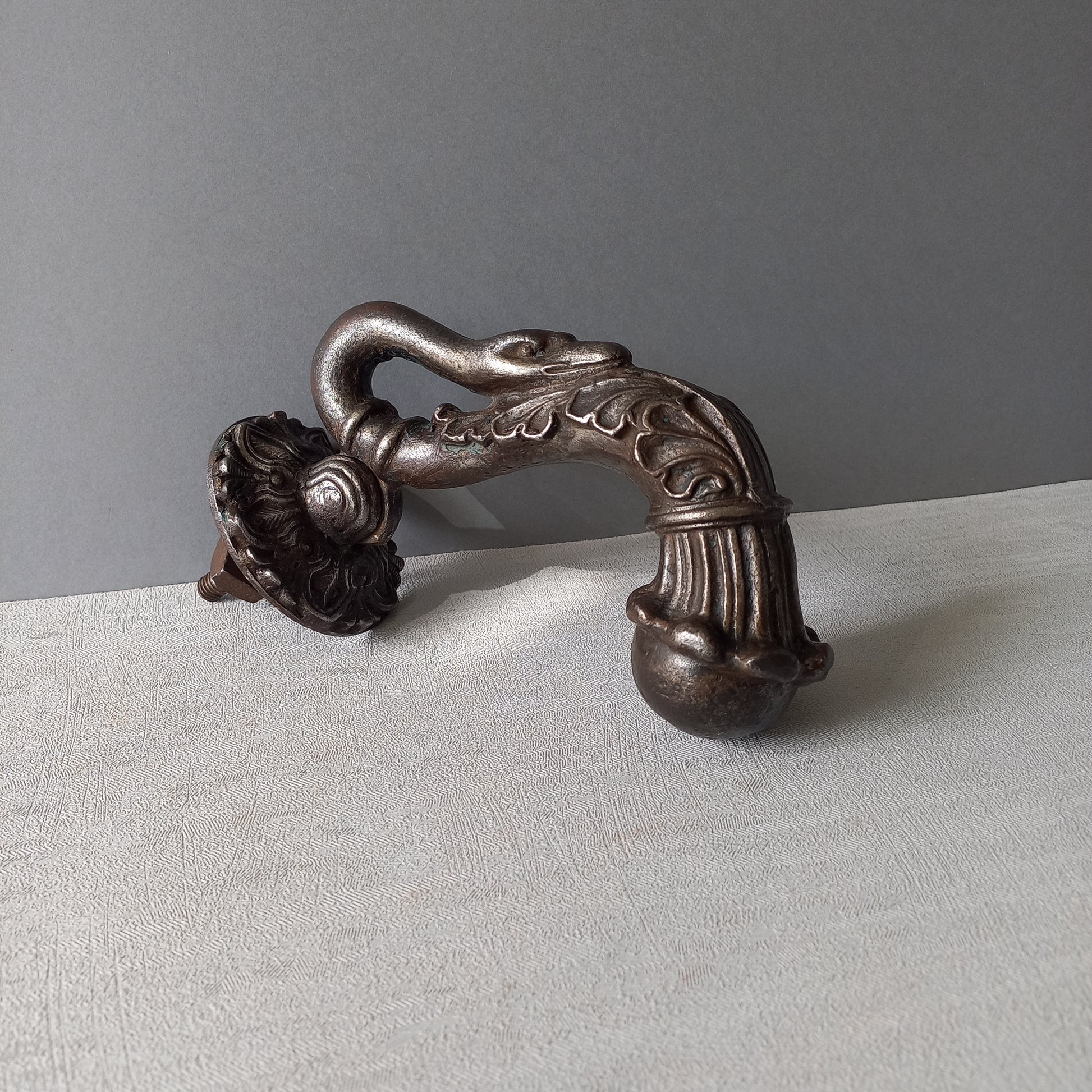 A stunning and large antique cast iron decorative door knocker with an elegant swan's neck and head, a very heavy and original antique piece purchased in south west France.