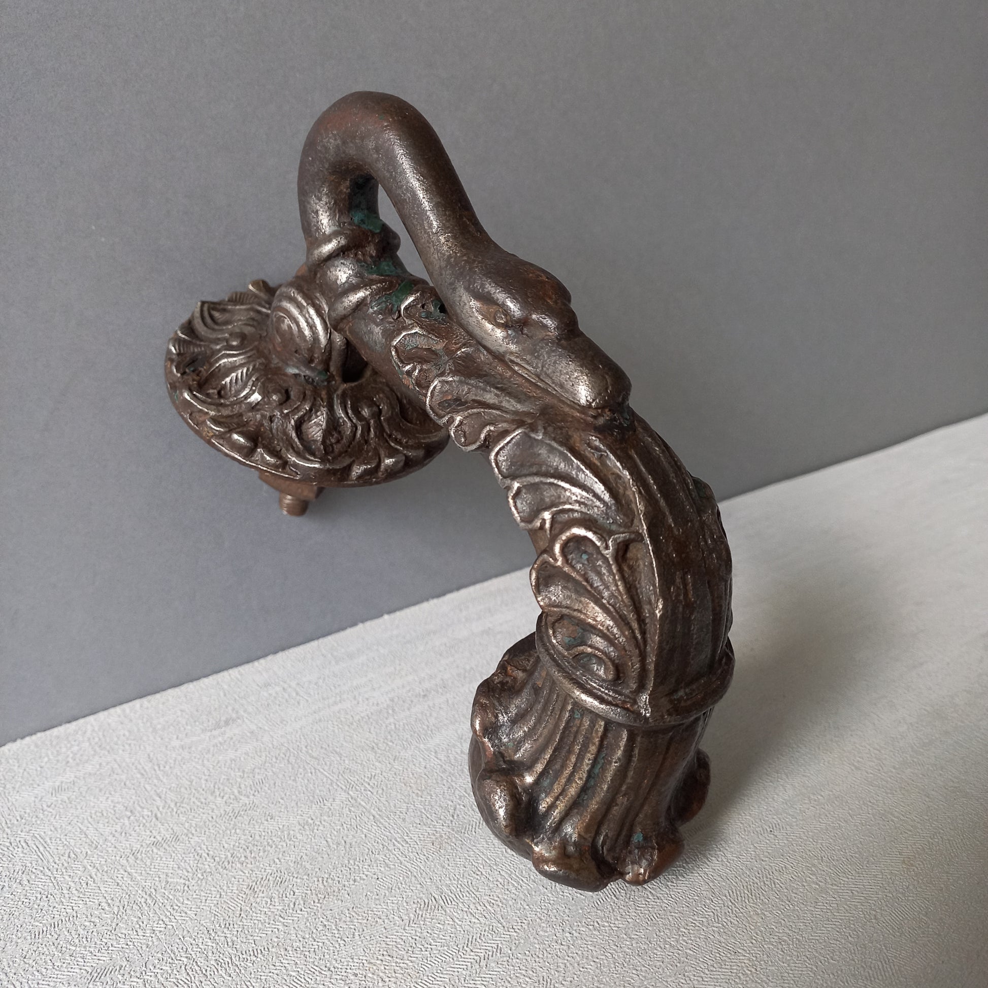 A stunning and large antique cast iron decorative door knocker with an elegant swan's neck and head, a very heavy and original antique piece purchased in south west France.