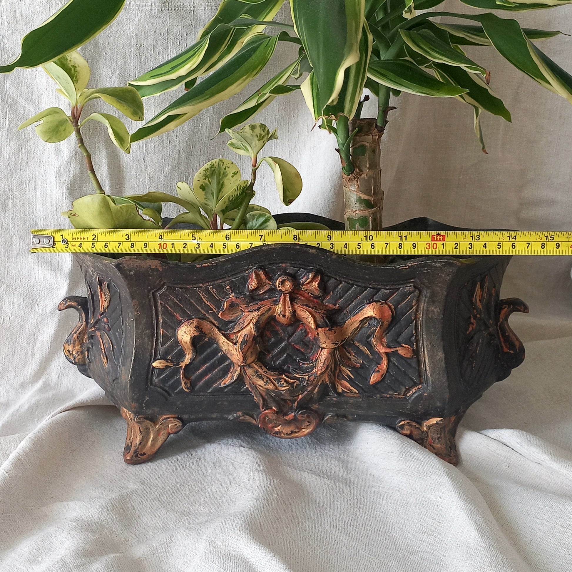 A stunning French antique decorative cast iron planter with patina of age suitable for both interior and exterior use - we rarely come across them these days so this was an exciting find.
The planter is in a striking and wonderfully aged black colour with gold coloured detailing in relief - there's some great paint chipping off areas of the gold paint showing small areas of red beneath, and also chipping from the black paint showing rusty patina, all of which add to the antique character of this beautiful