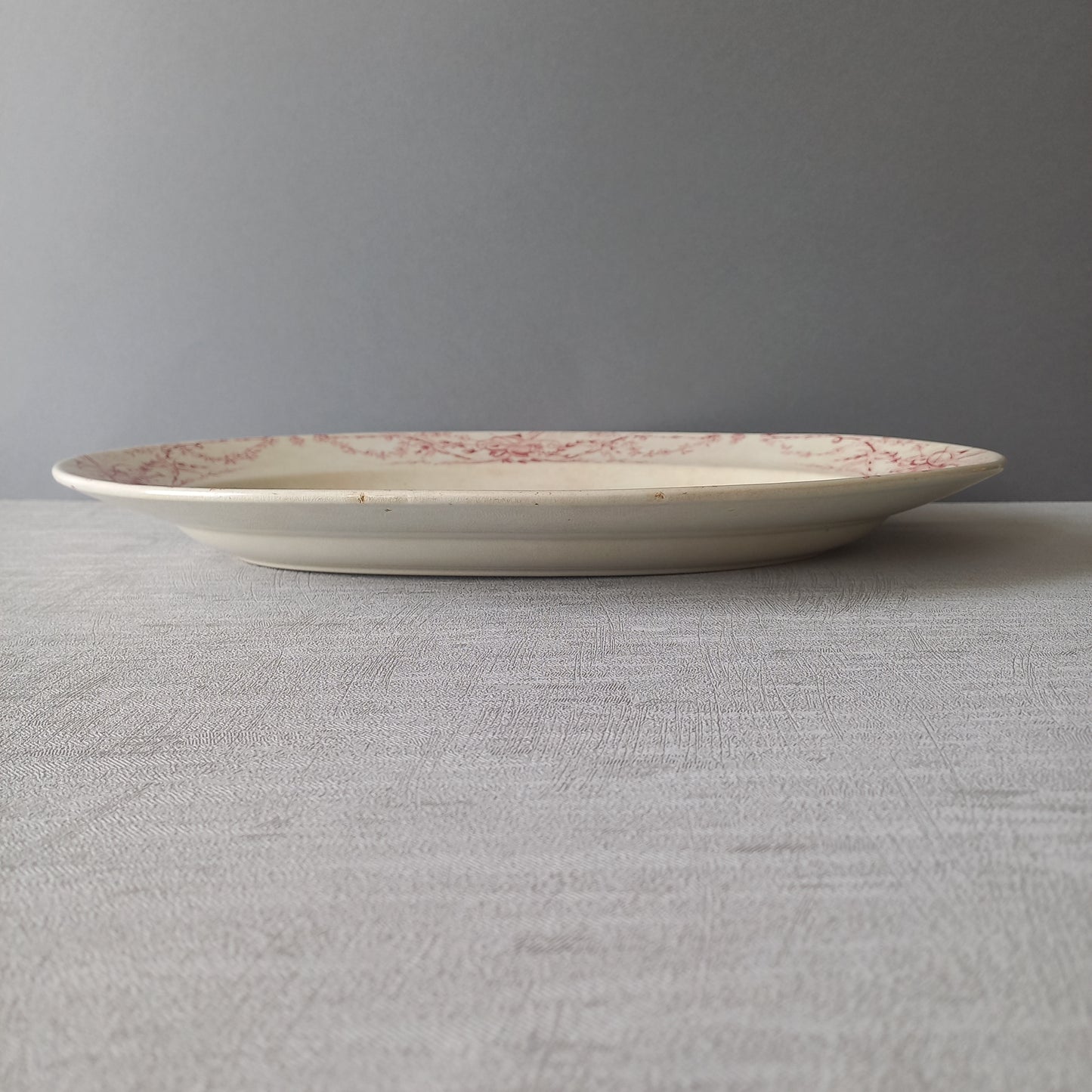 Plat ovale ancien français en terre de fer blanc crème avec motif en transfert rose par KG Lunéville