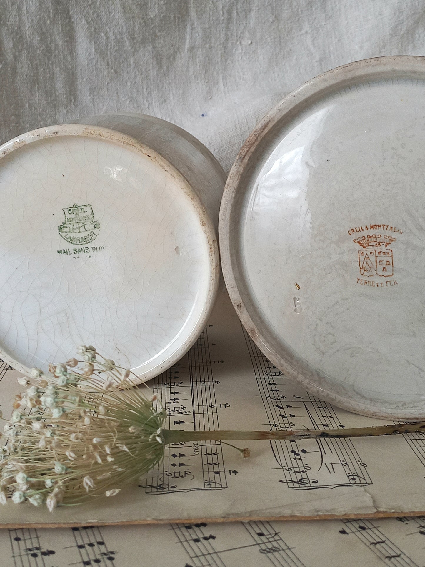 Two ceramic plates with visible branding on a sheet of music