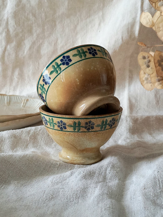 Stack of ceramic bowls with floral patterns on a textured fabric background