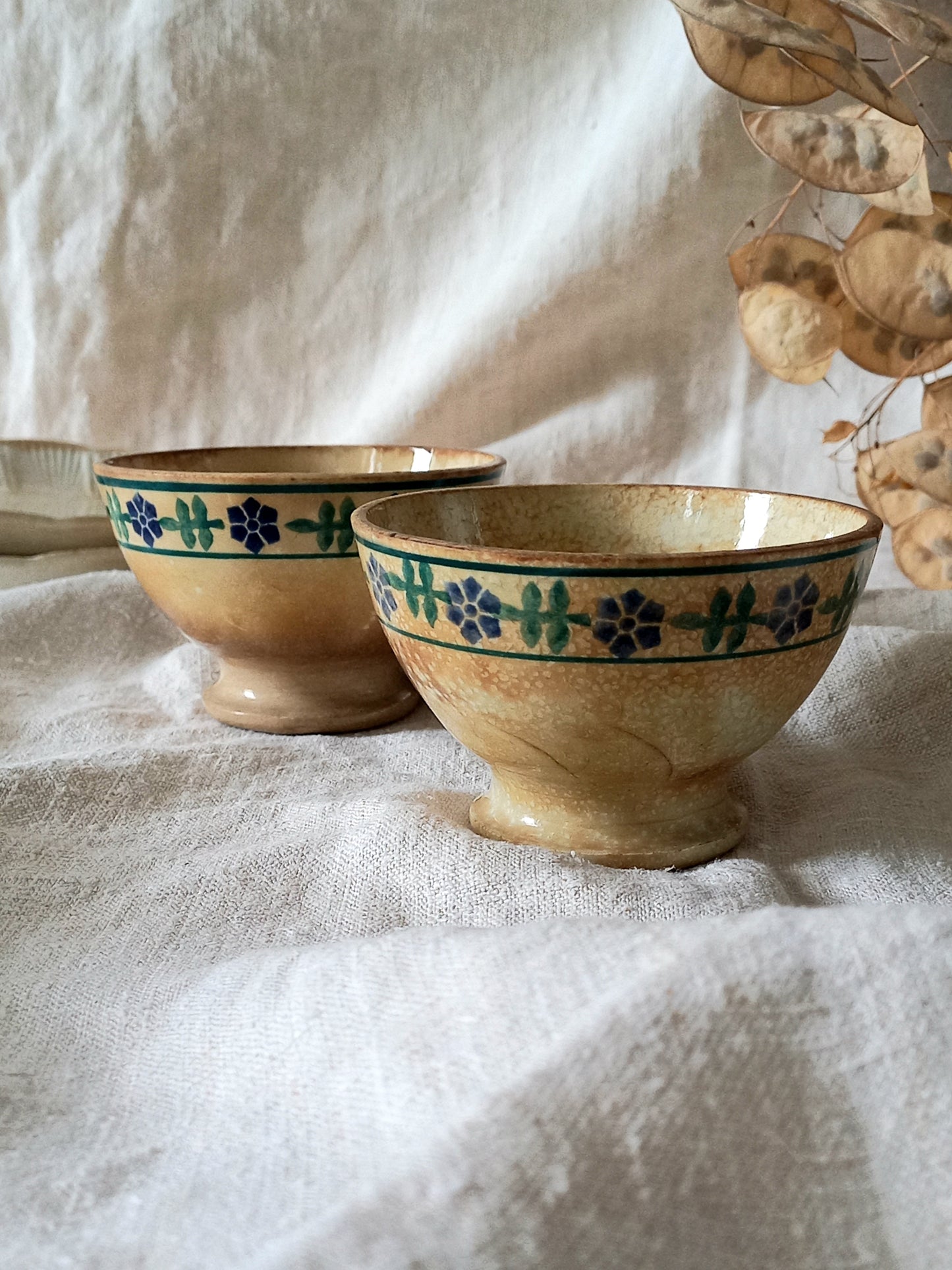 Two ceramic bowls with floral patterns on a textured surface