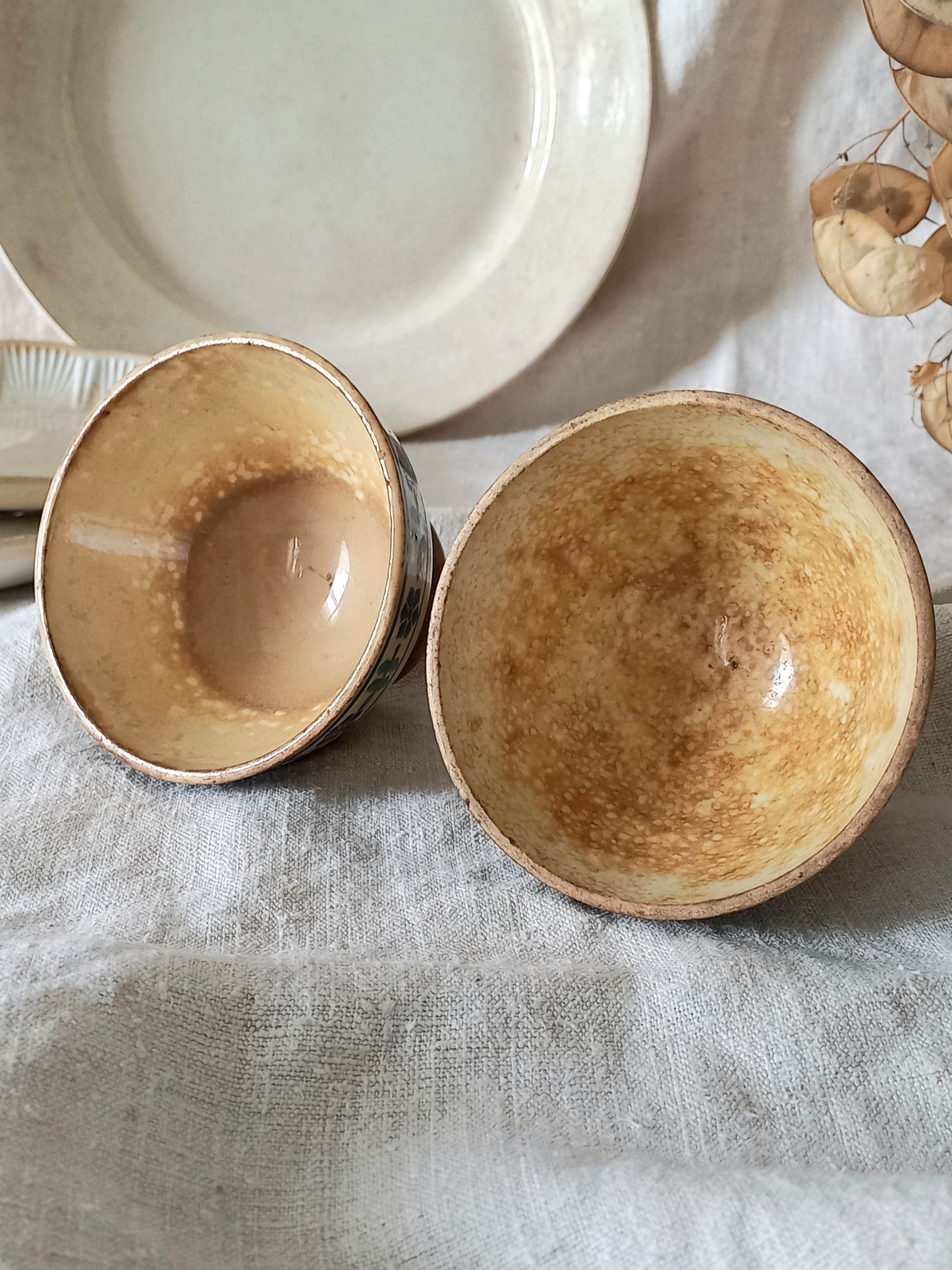 Two ceramic bowls on a textured surface with a neutral background
