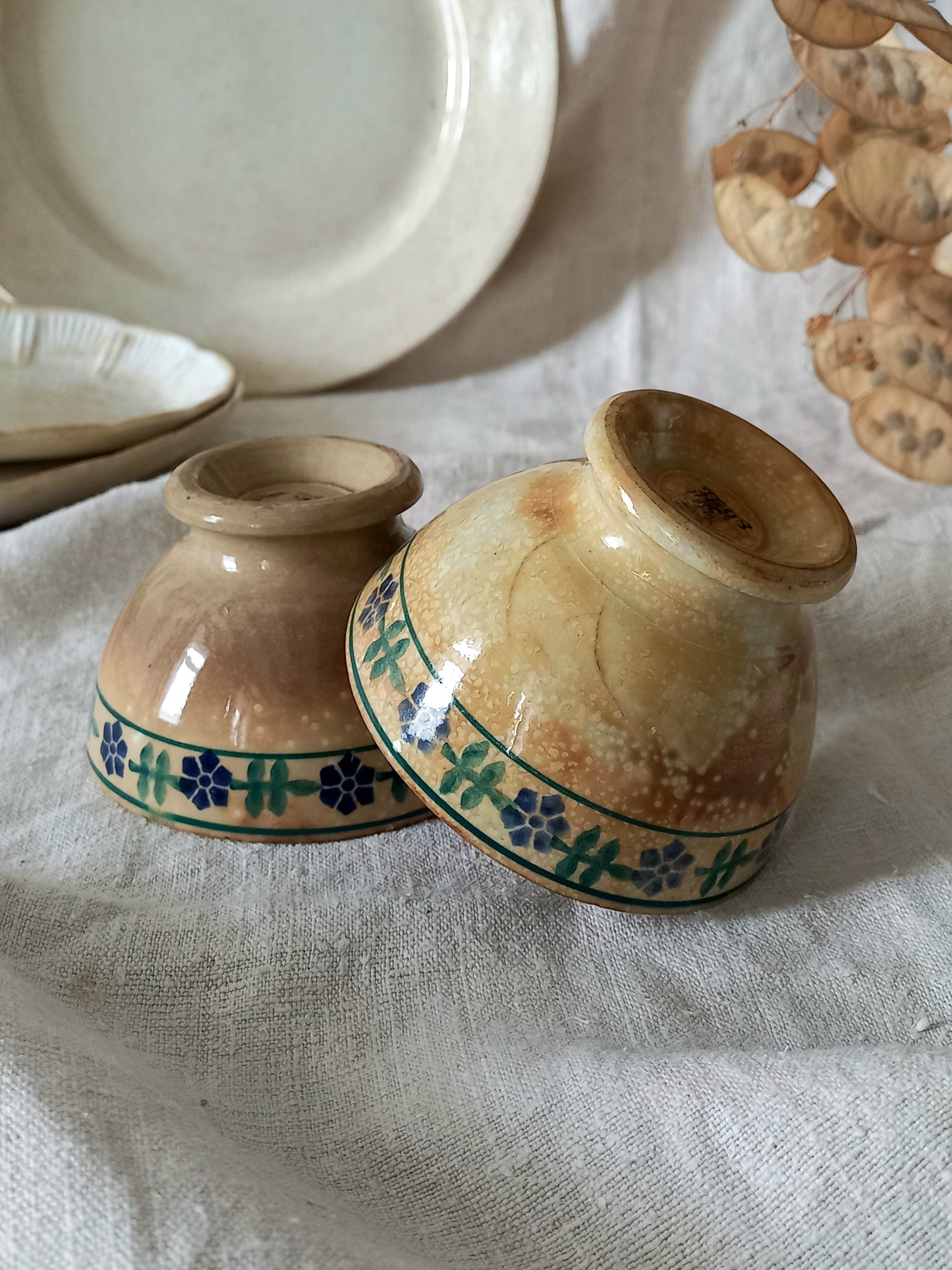 Two ceramic containers with floral patterns on a textured surface