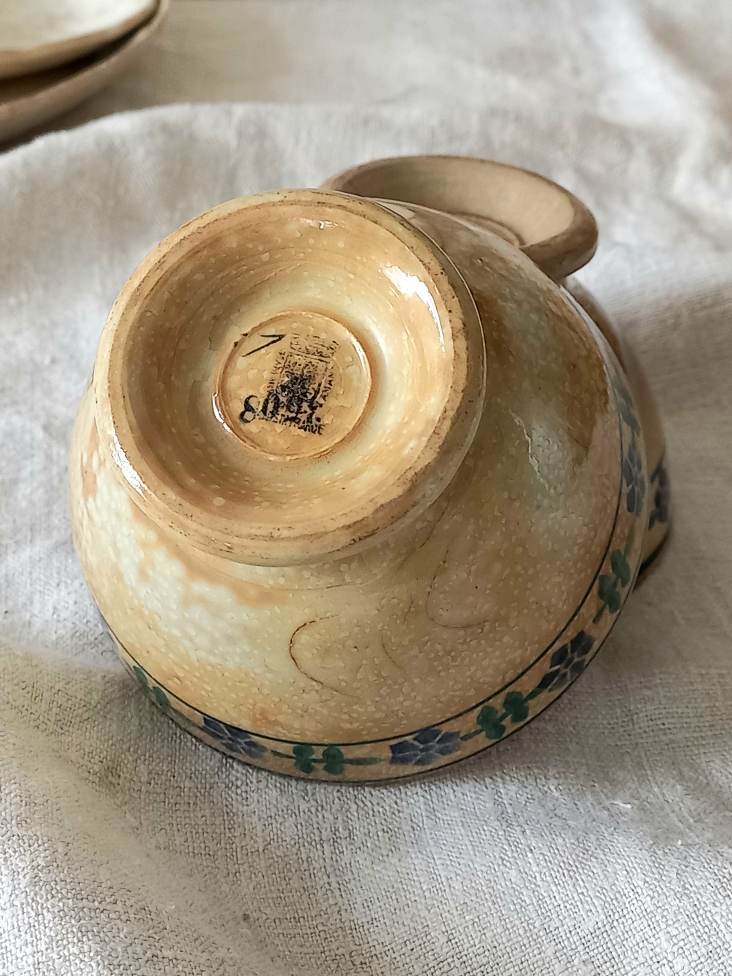 Ceramic bowl with a visible brand logo on a textured surface