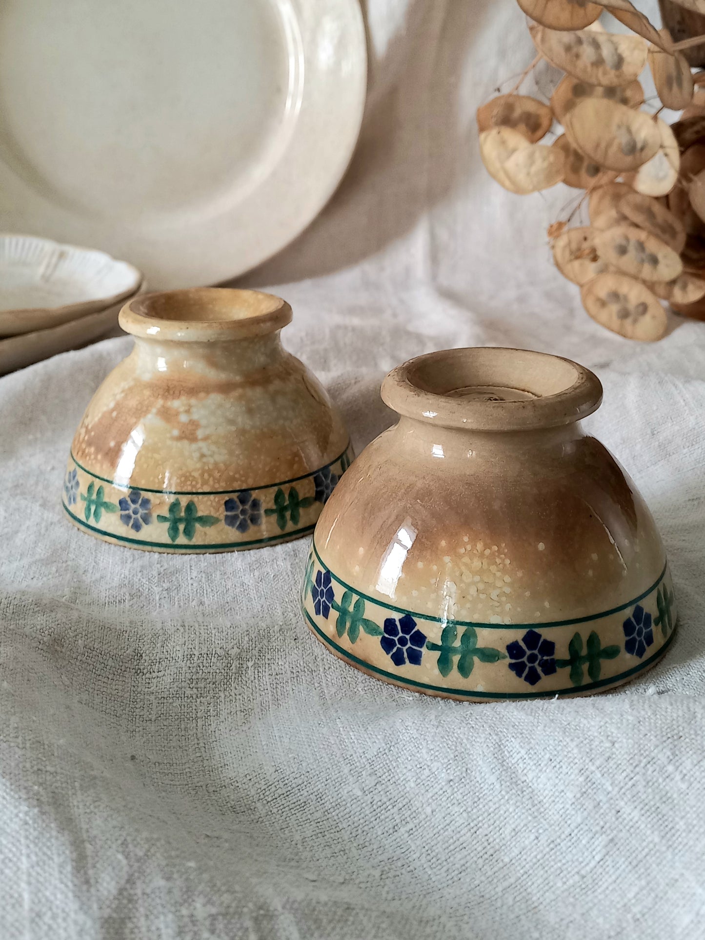 Two ceramic bowls with decorative patterns on a textured surface