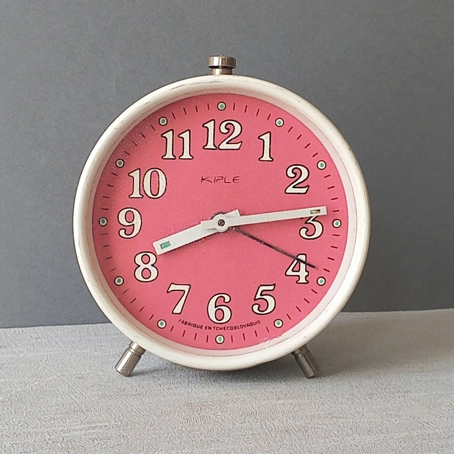 A wonderful vintage alarm clock in an eye-catching white and pink color scheme. This old clock is in working condition including the alarm and has a nice soothing ticking sound too. A great piece of European history from the former country of Czechoslovakia.