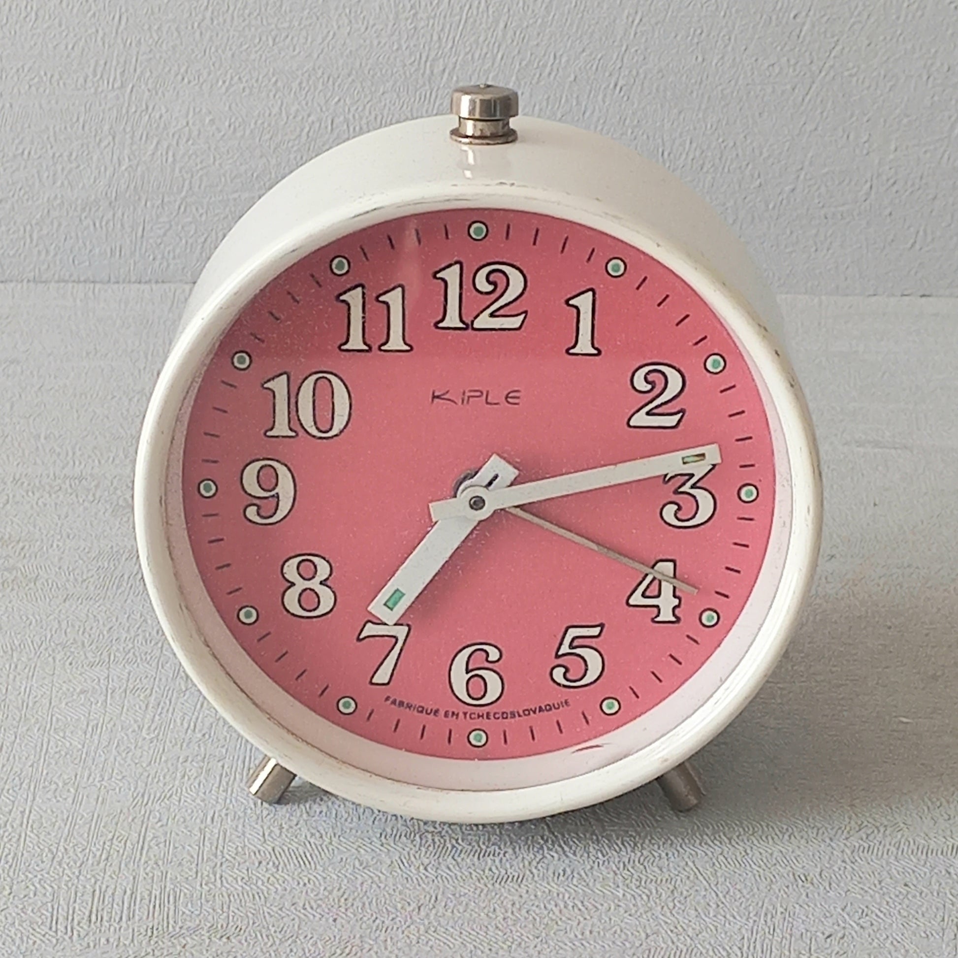 A wonderful vintage alarm clock in an eye-catching white and pink color scheme. This old clock is in working condition including the alarm and has a nice soothing ticking sound too. A great piece of European history from the former country of Czechoslovakia