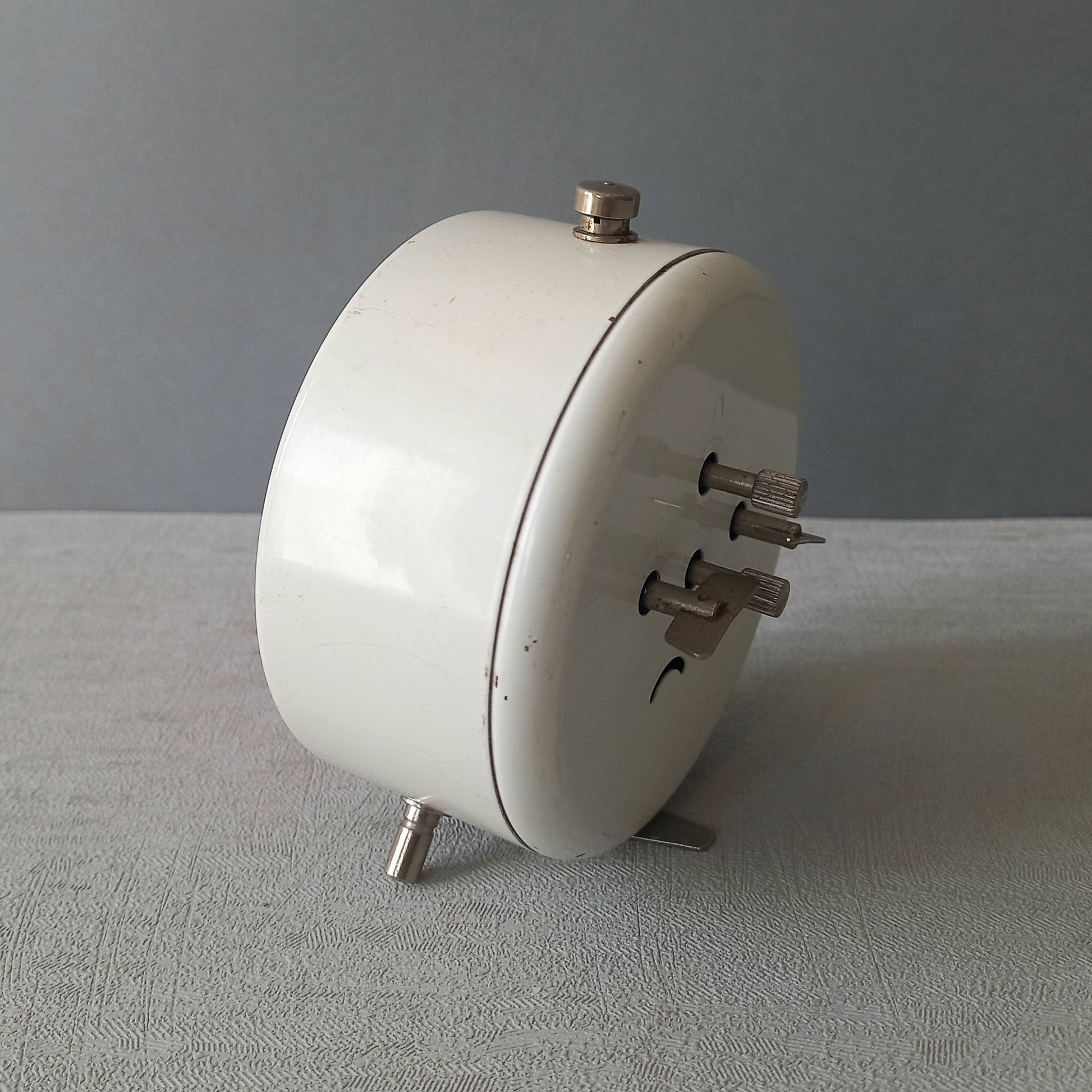 A wonderful vintage alarm clock in an eye-catching white and pink color scheme. This old clock is in working condition including the alarm and has a nice soothing ticking sound too. A great piece of European history from the former country of Czechoslovakia.