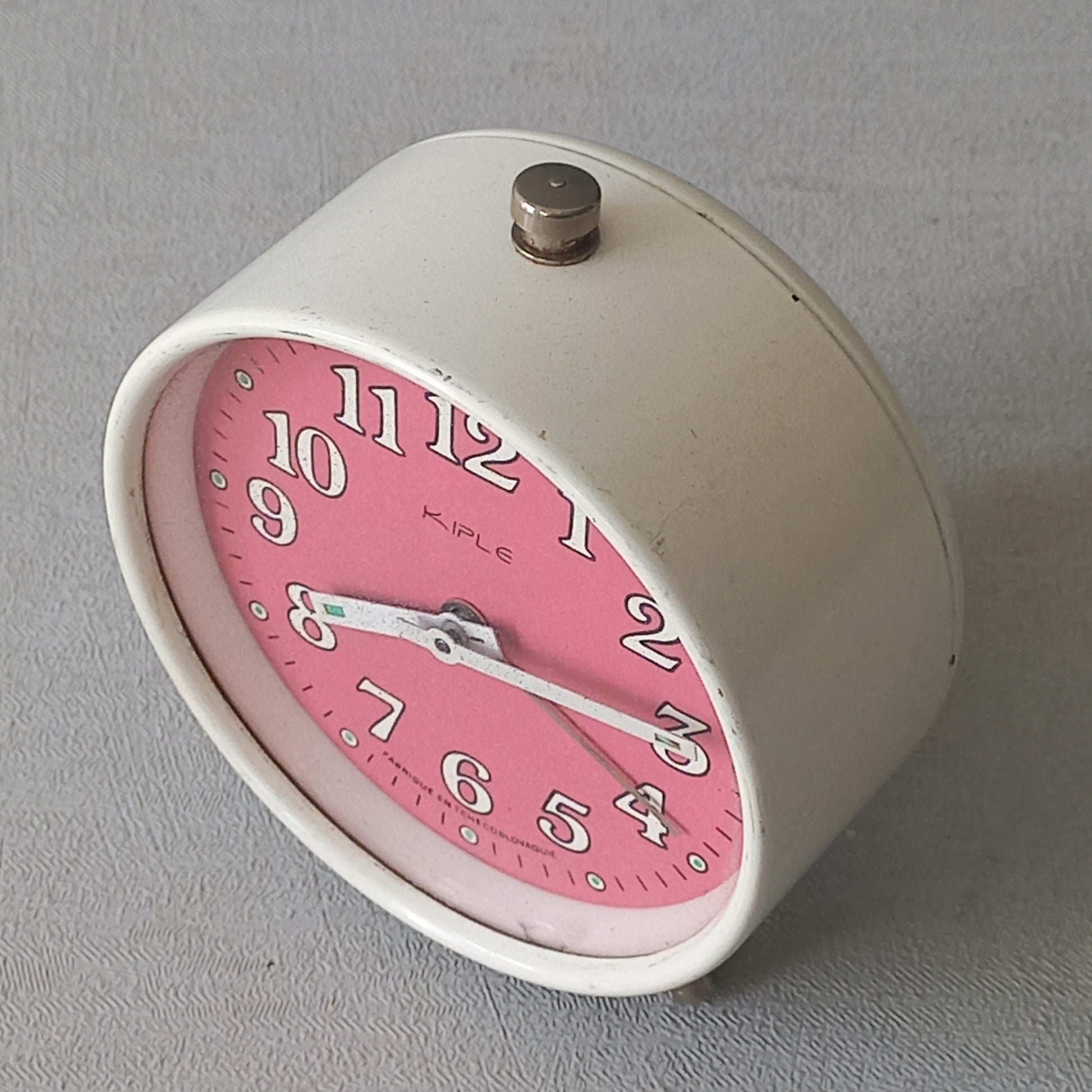 A wonderful vintage alarm clock in an eye-catching white and pink color scheme. This old clock is in working condition including the alarm and has a nice soothing ticking sound too. A great piece of European history from the former country of Czechoslovakia.