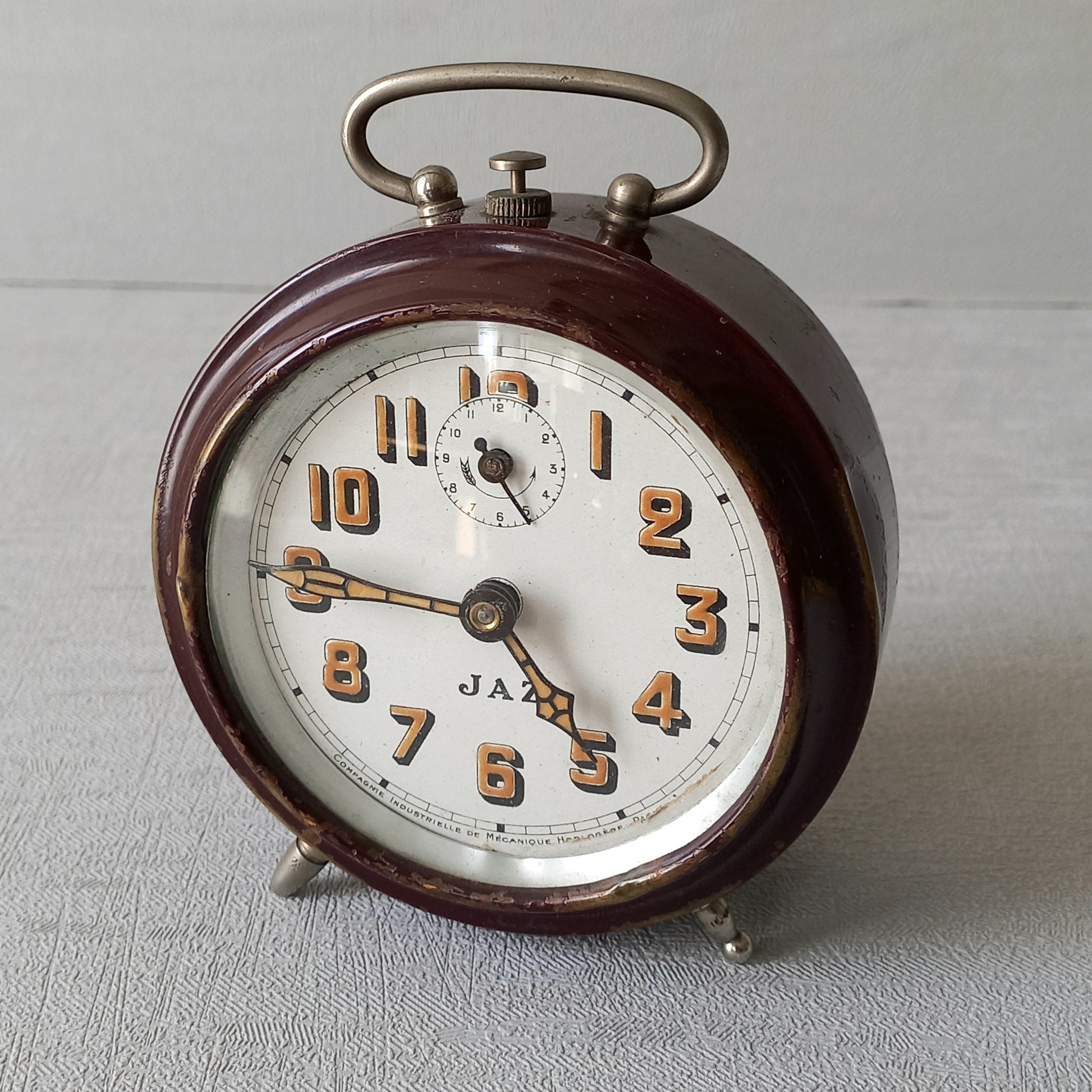 A handsome little vintage alarm clock by premier French manufacturer, Jaz.
This wonderful little clock is in semi-working condition including the alarm, although I should note that being an old time piece dating from the pre-1940 period he's temperamental and sometimes will just stop working, although all that's needed is a gentle shake from side to side and he will once more begin to tick - sometimes you might have to repeat this and have patience with him.