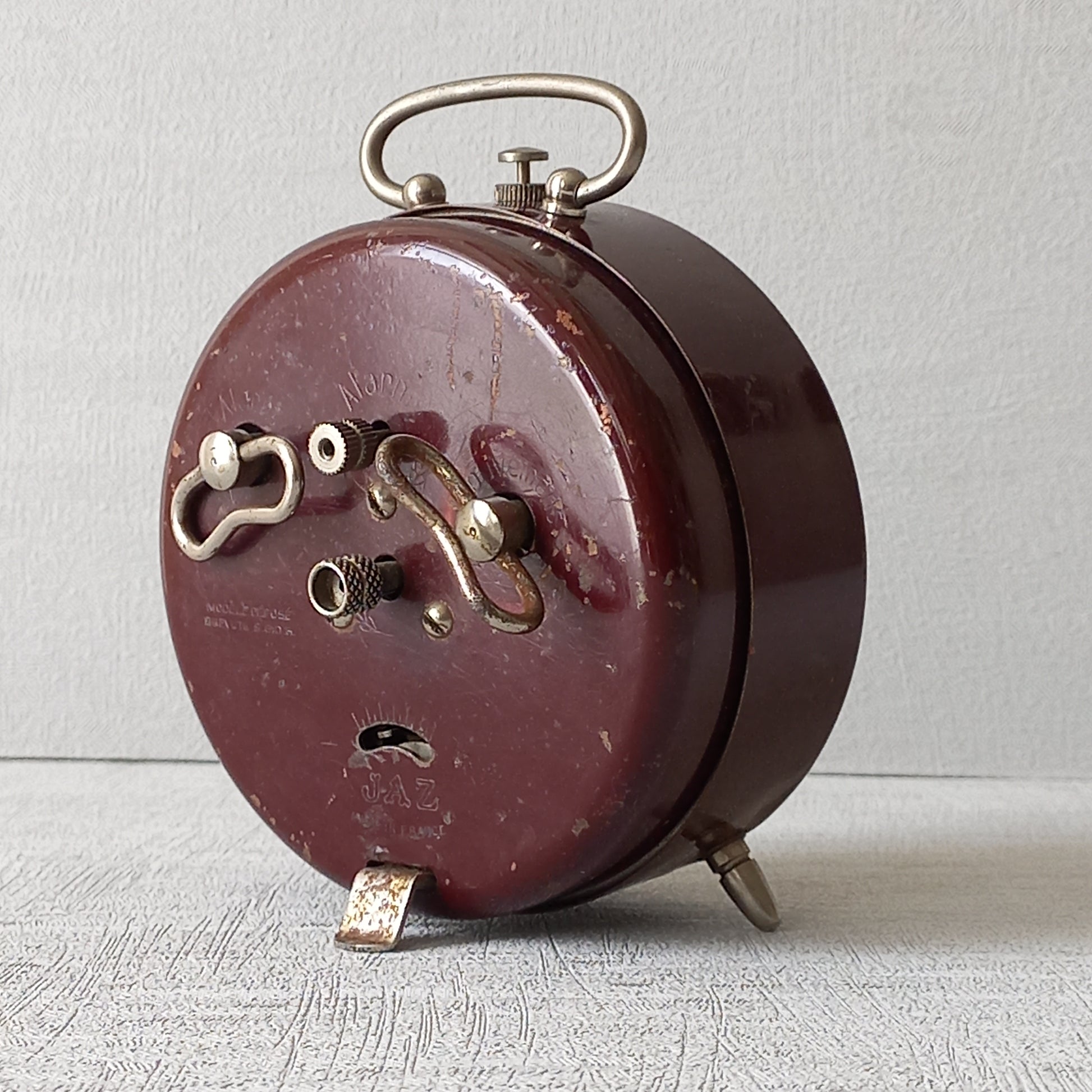 A handsome little vintage alarm clock by premier French manufacturer, Jaz.
This wonderful little clock is in semi-working condition including the alarm, although I should note that being an old time piece dating from the pre-1940 period he's temperamental and sometimes will just stop working, although all that's needed is a gentle shake from side to side and he will once more begin to tick - sometimes you might have to repeat this and have patience with him.