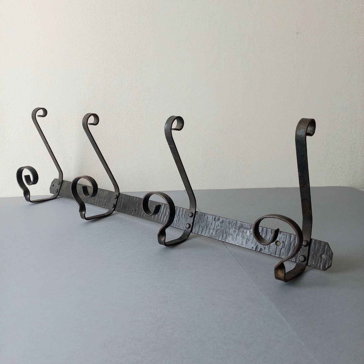 A large French vintage metal coat and hat rack for 4 coats and hats, a hand-made piece that is sturdy and can be screwed directly to your wall using the holes already in the wall bracket. The colour of the coat rack is a pleasing worn satin black with traces of gold showing through in places which give it a nice aged appearance.