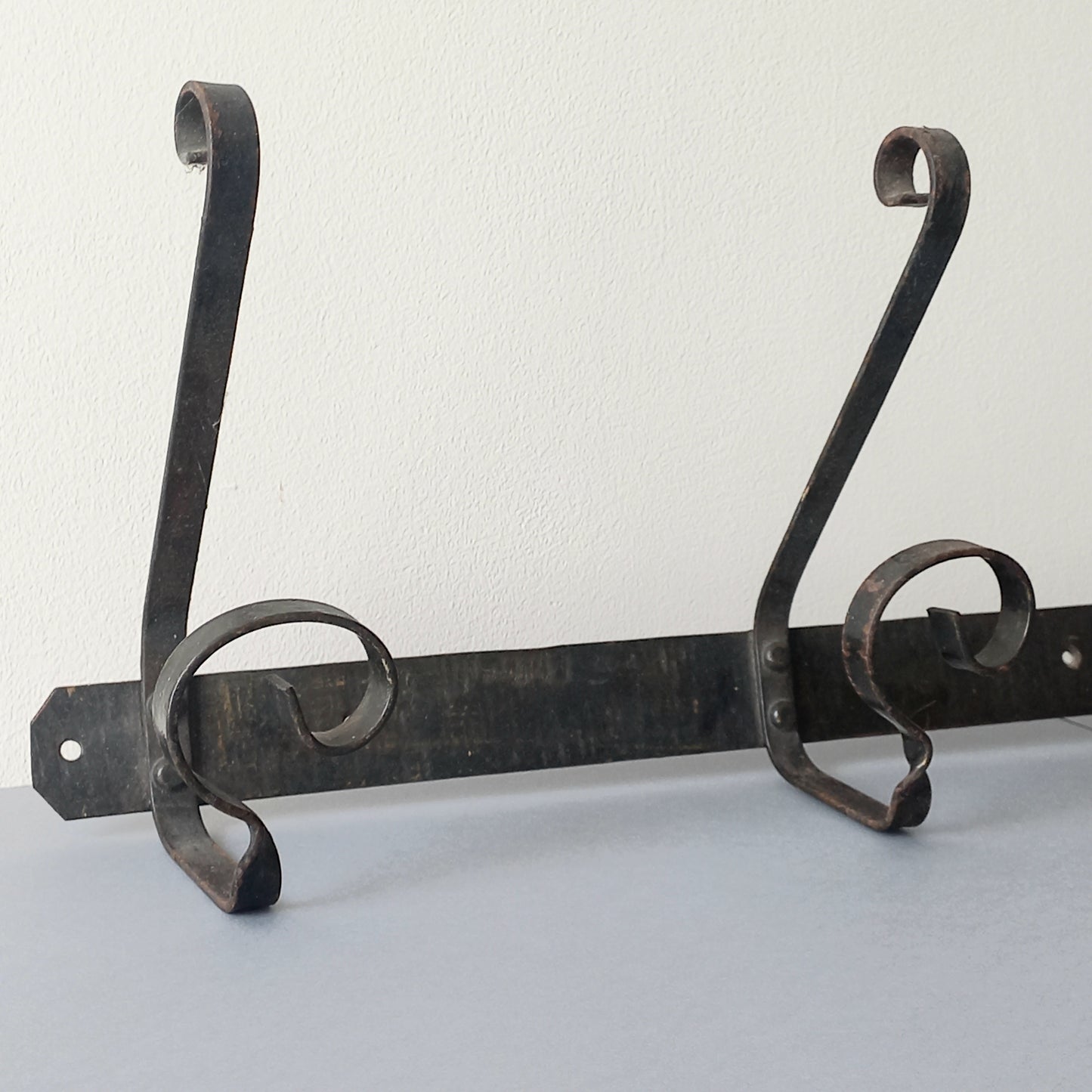 A large French vintage metal coat and hat rack for 4 coats and hats, a hand-made piece that is sturdy and can be screwed directly to your wall using the holes already in the wall bracket. The colour of the coat rack is a pleasing worn satin black with traces of gold showing through in places which give it a nice aged appearance.