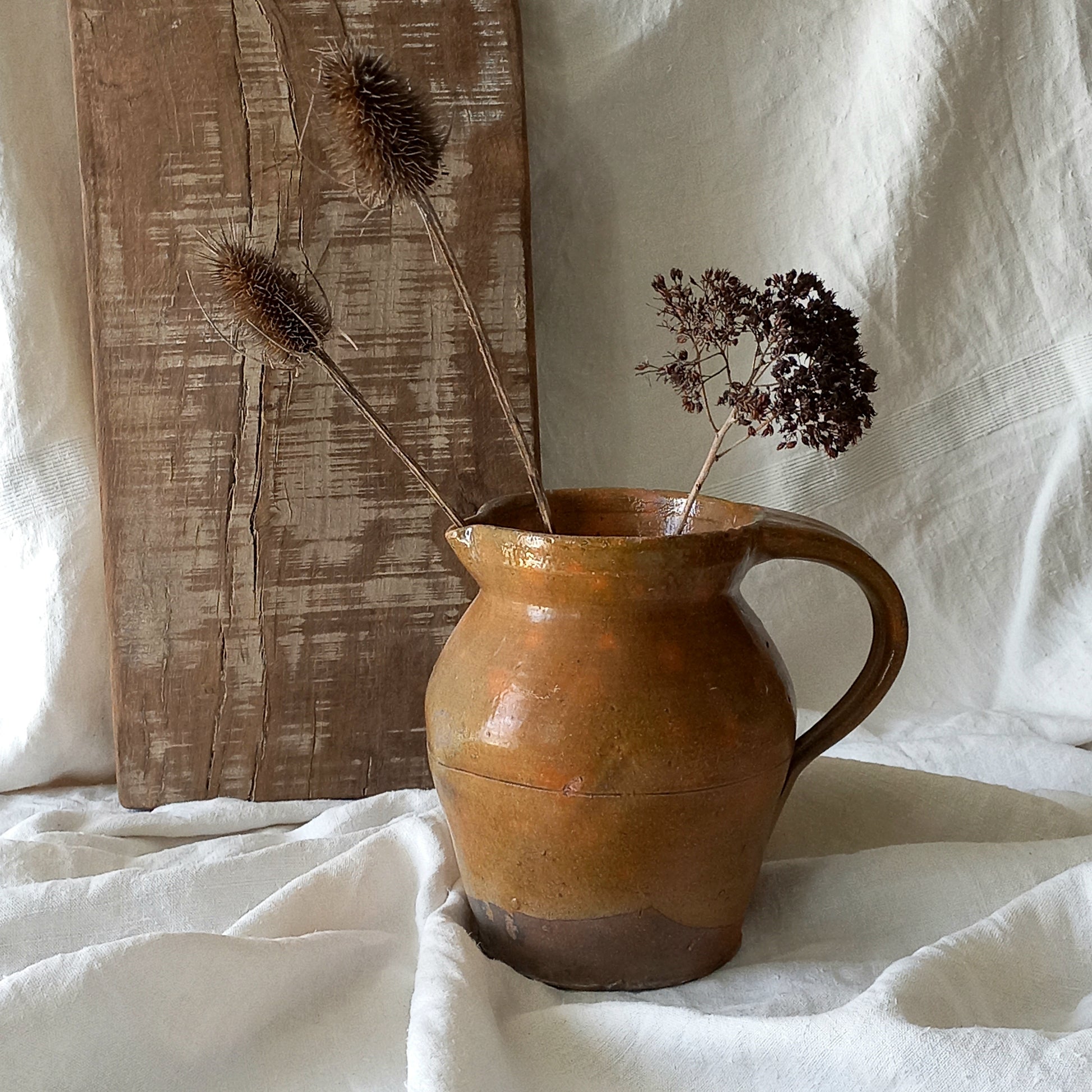 A rustic antique pottery glazed jug, a charming hand-made piece in a lovely shade of ochre with subtle traces of green. Underneath is the French maker's mark.
This piece of stoneware will look wonderful in any interior, particularly those of a rustic, country and farmhouse nature.