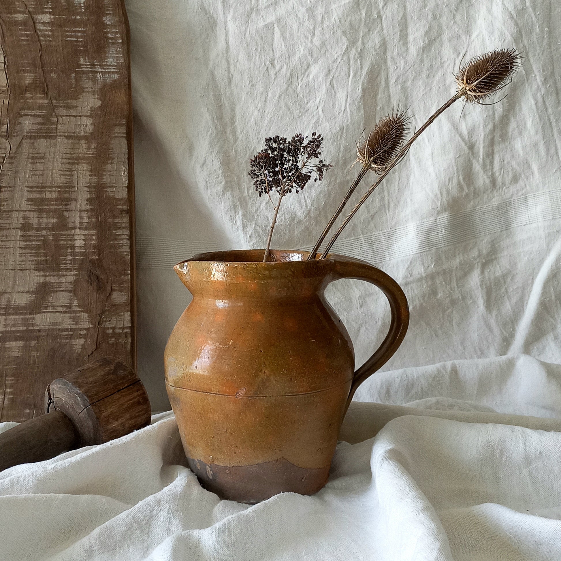 A rustic antique pottery glazed jug, a charming hand-made piece in a lovely shade of ochre with subtle traces of green. Underneath is the French maker's mark.
This piece of stoneware will look wonderful in any interior, particularly those of a rustic, country and farmhouse nature.