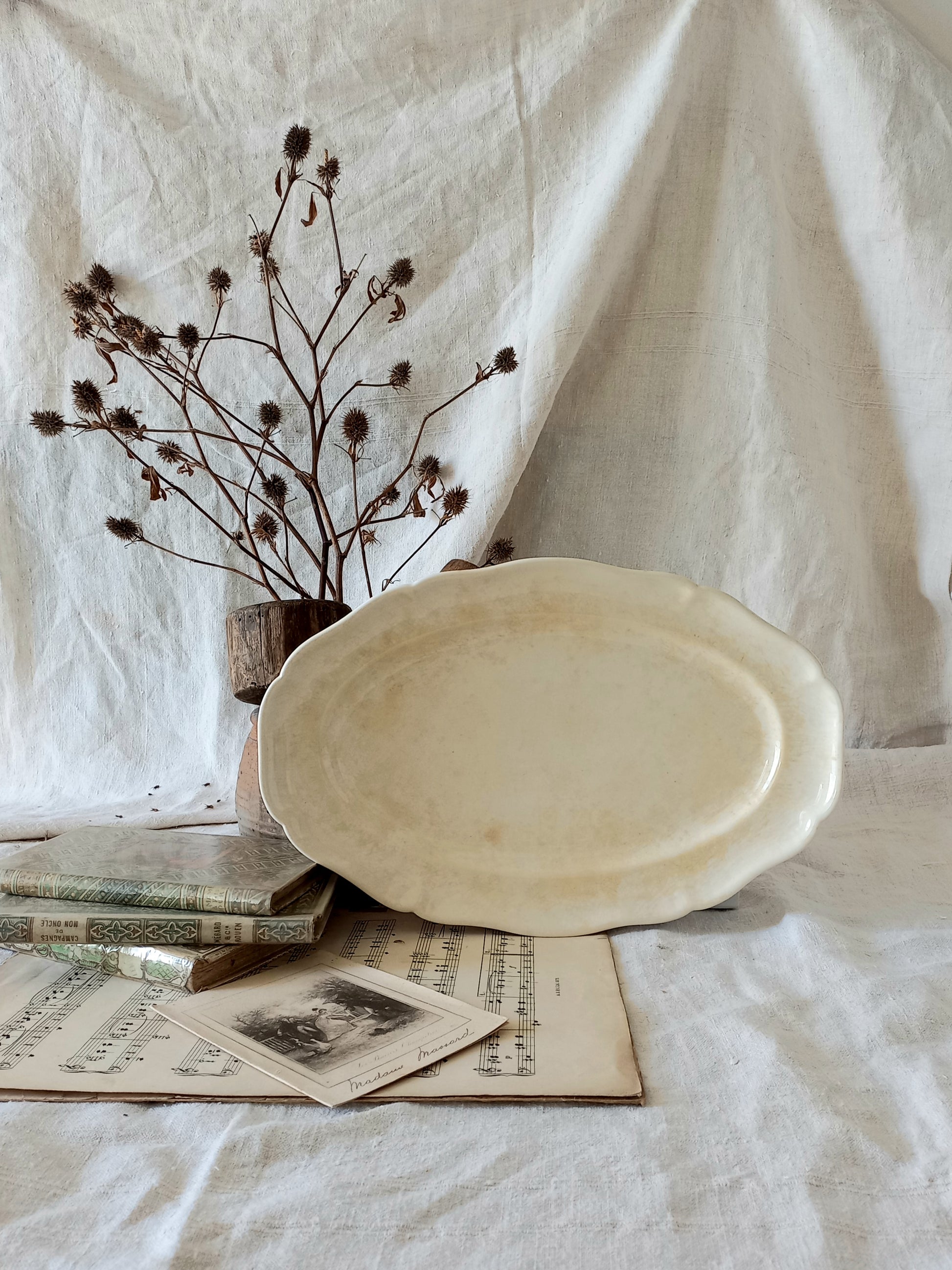 A beautiful vintage oval ironstone serving plate with decorative edges in a time-worn creamy white with super tea-staining that gives it that shabby chic finish many of us desire.