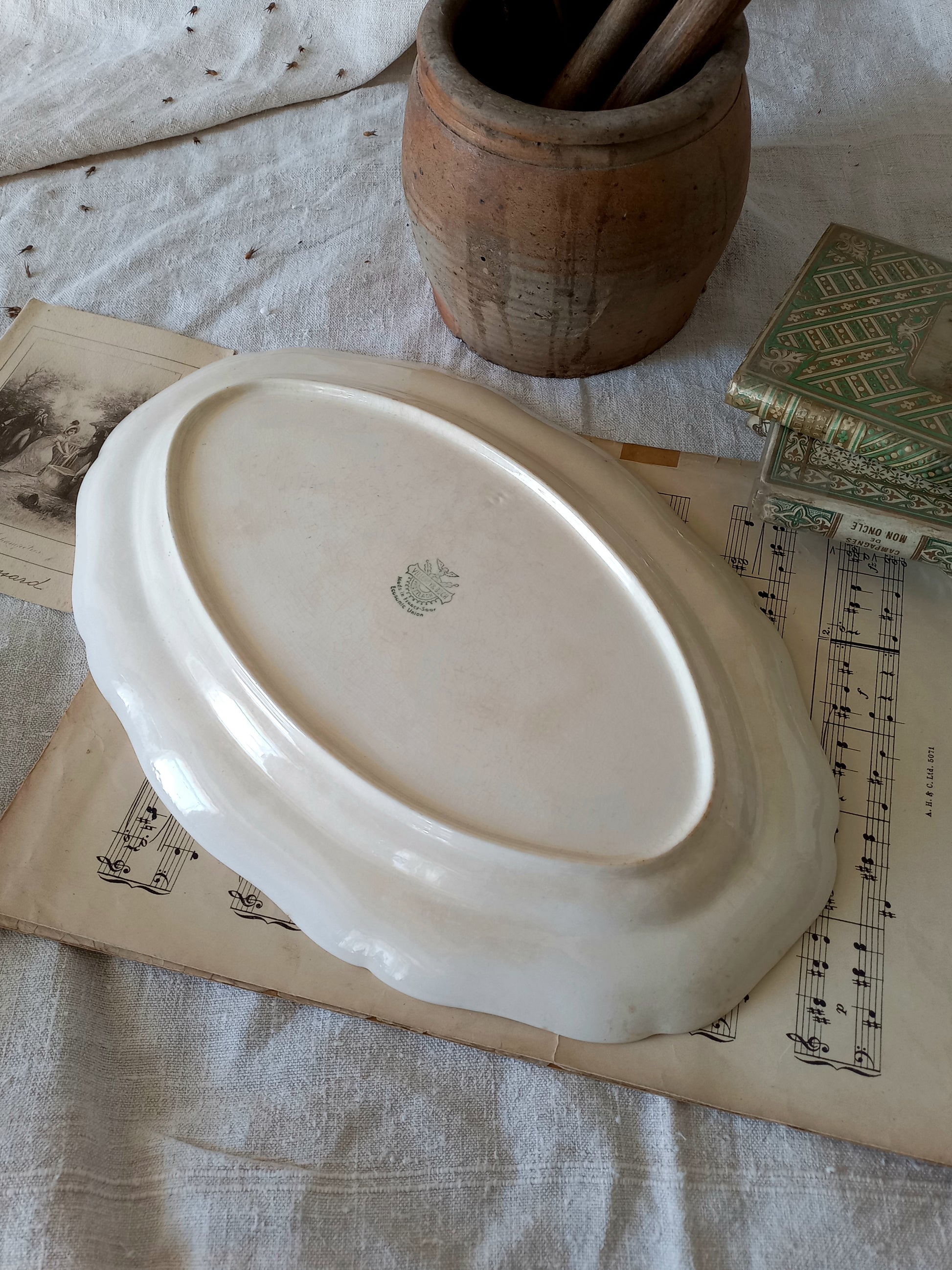 A beautiful vintage oval ironstone serving plate with decorative edges in a time-worn creamy white with super tea-staining that gives it that shabby chic finish many of us desire.