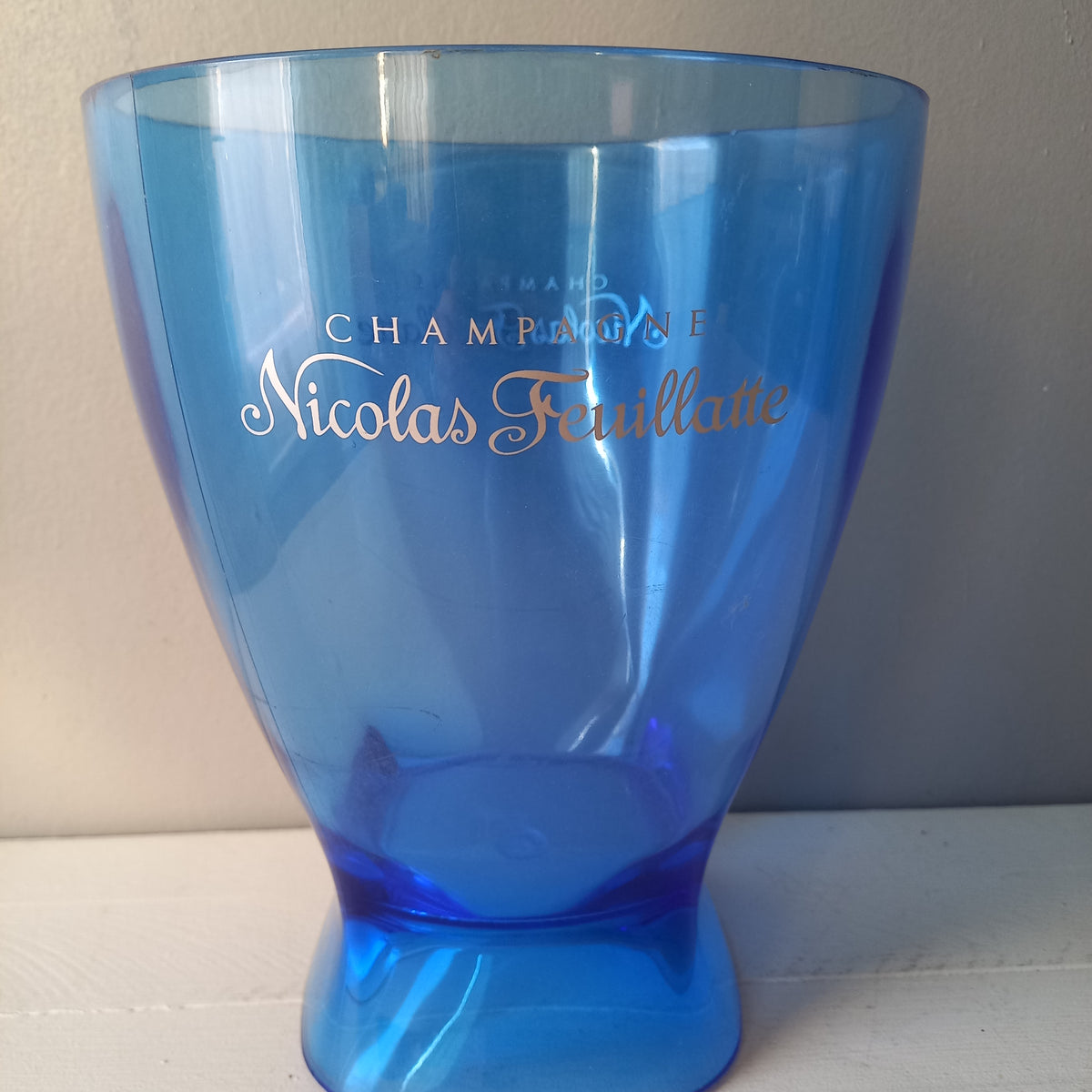 Vintage Nicolas Feuillatte transparent blue champagne bucket made from resin or hardened plastic. Being a vintage item there are of course some scuffs and scratches in the plastic.